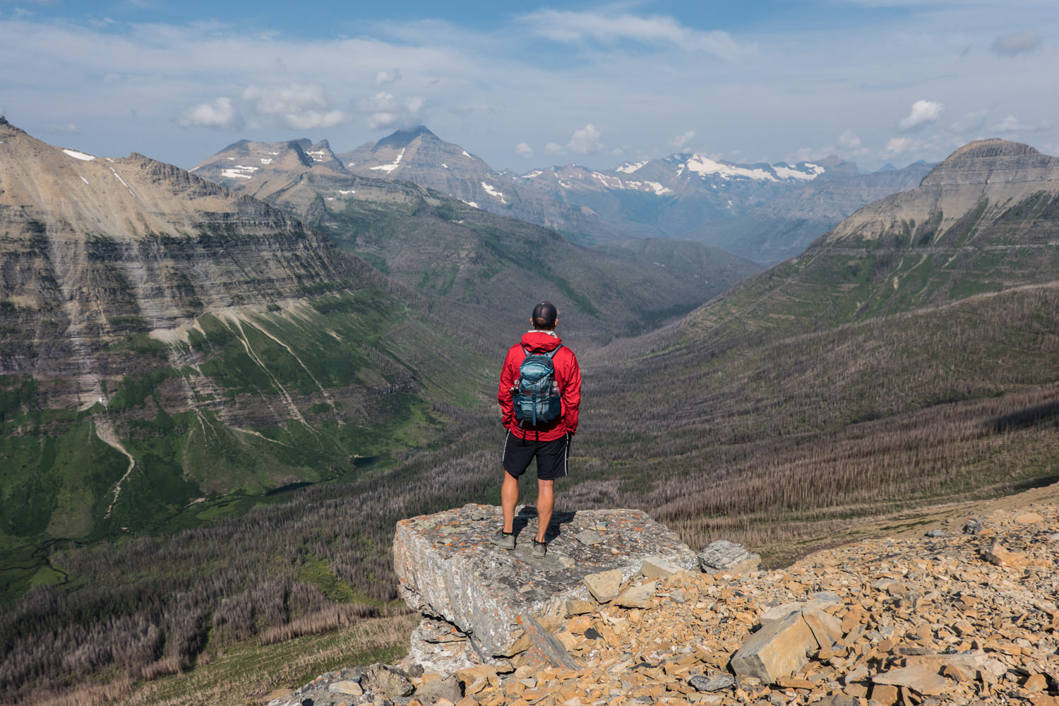 backpacker overlooking a valley created by a glacier.