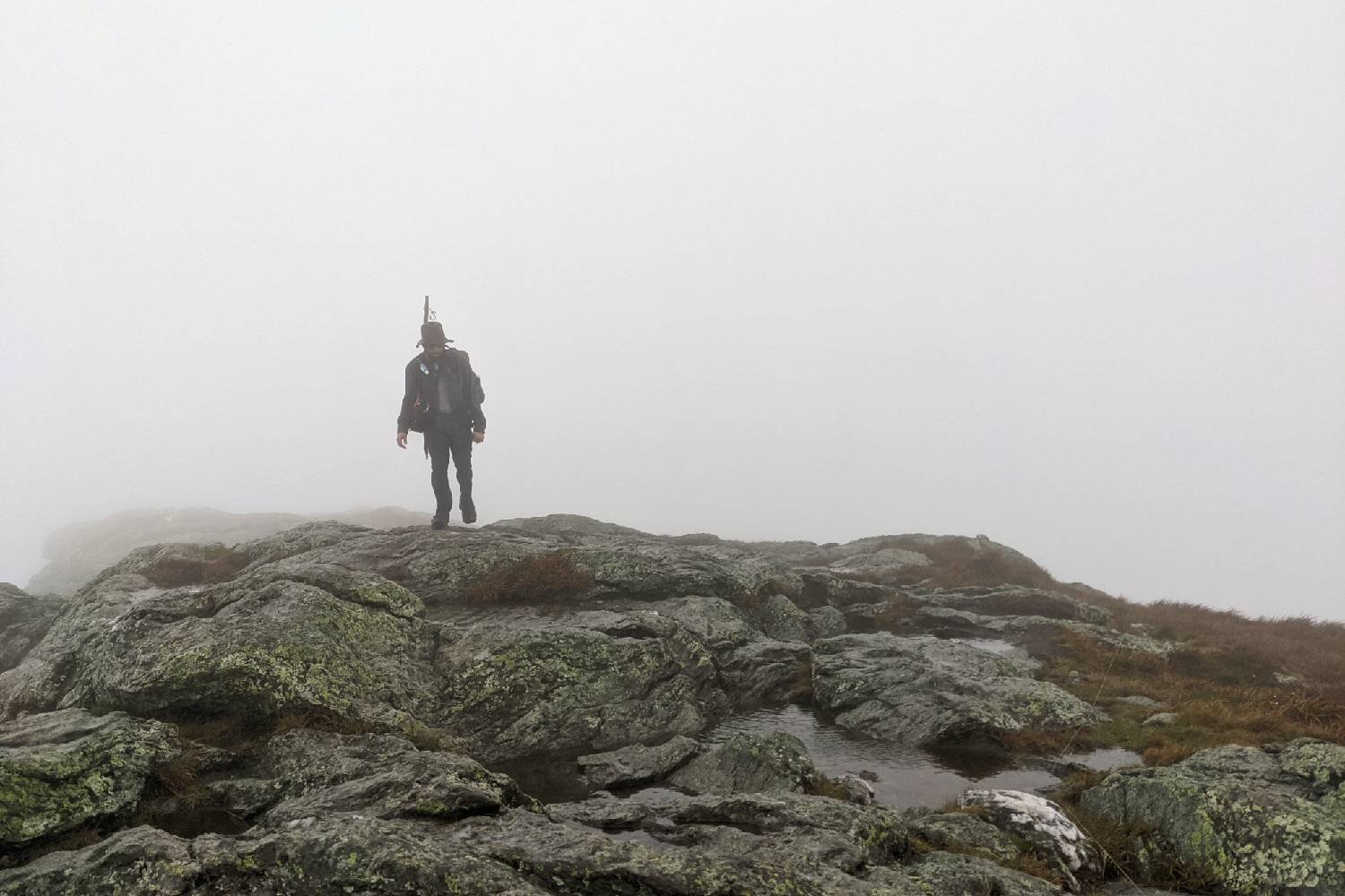 backpacker walking on a mountain in the mist.