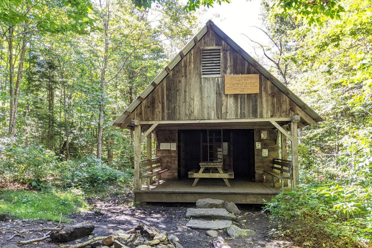 a cabin in the woods along the long trail in vermont on a sunny day.