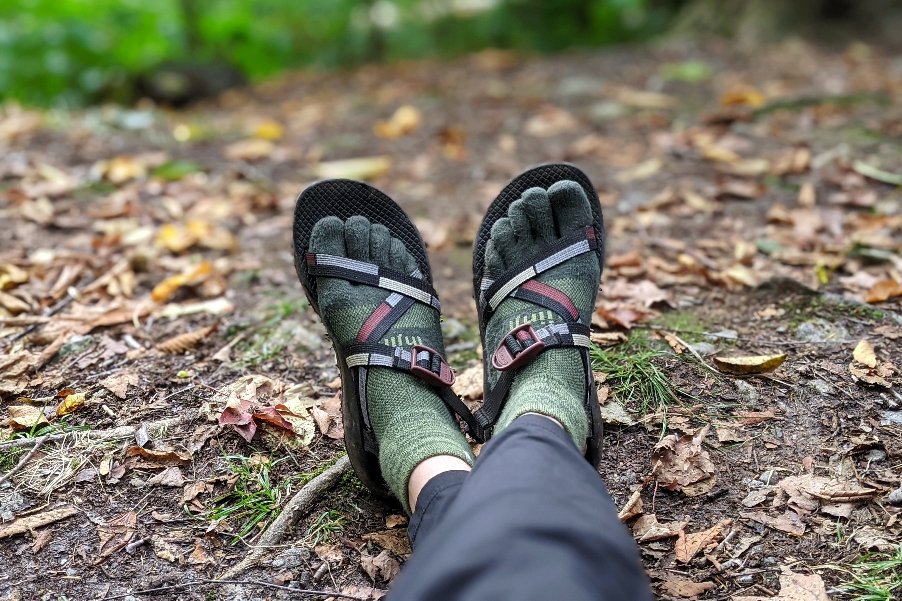 legs and feet of a thru-hiker wearing toe socks and chacos.
