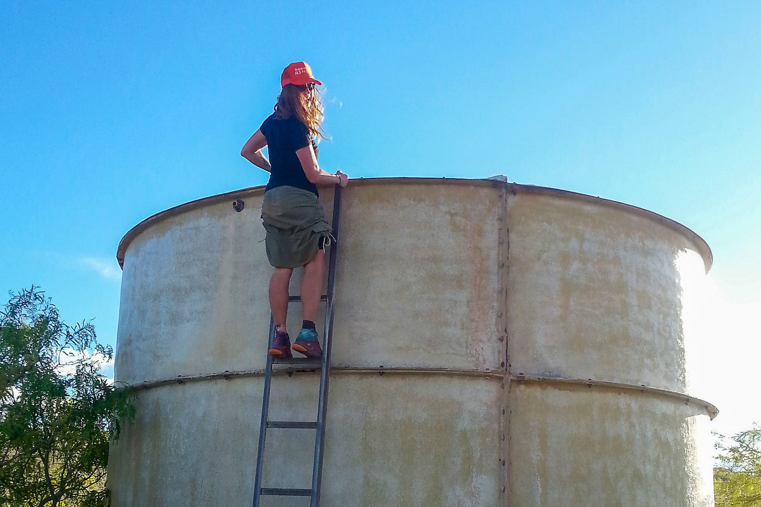 a water tank with a hiker on its ladder