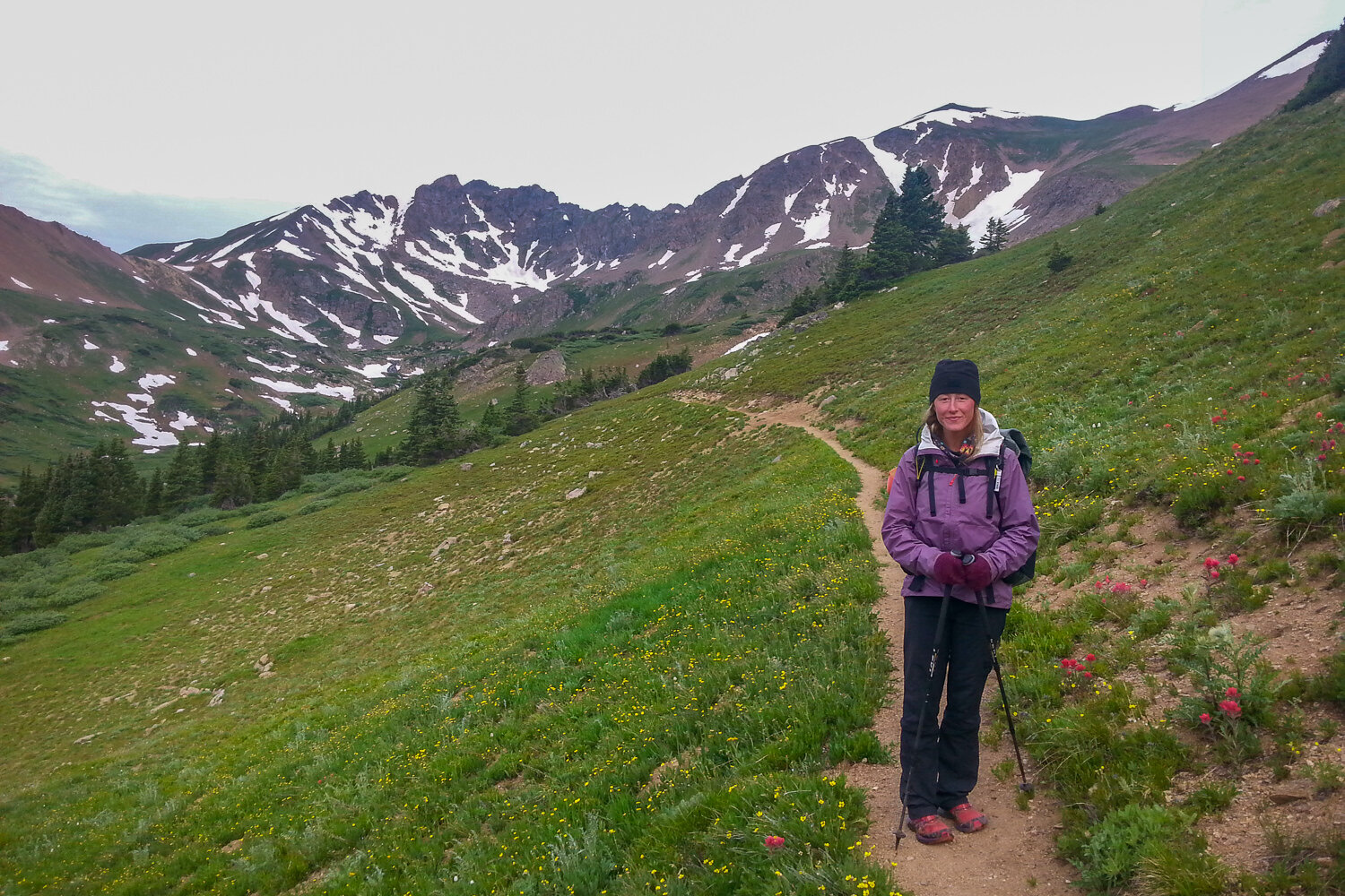 a backpacker thru-hiking on the CDT wearing warm layers on the trail.