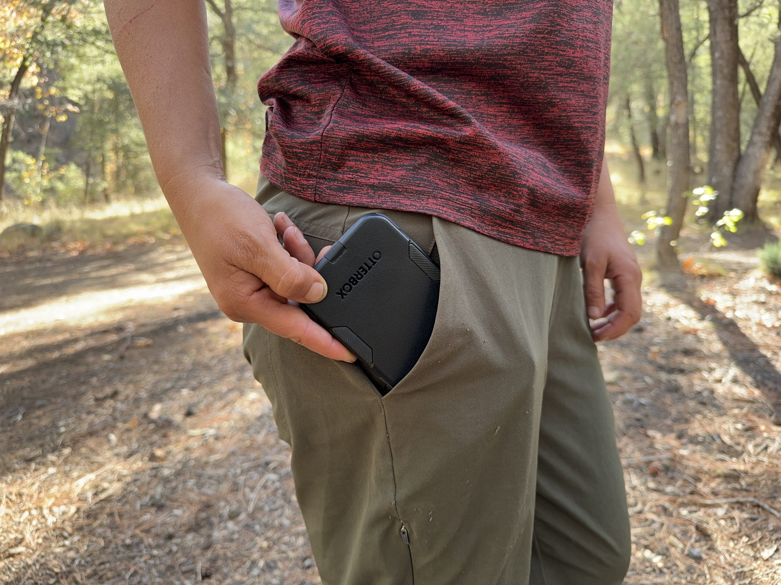 Close up of a phone being placed in the hip pocket of the Happy Hike pants.