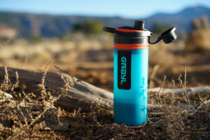 The Grayl GeoPress sits on the ground with mountains in the background.