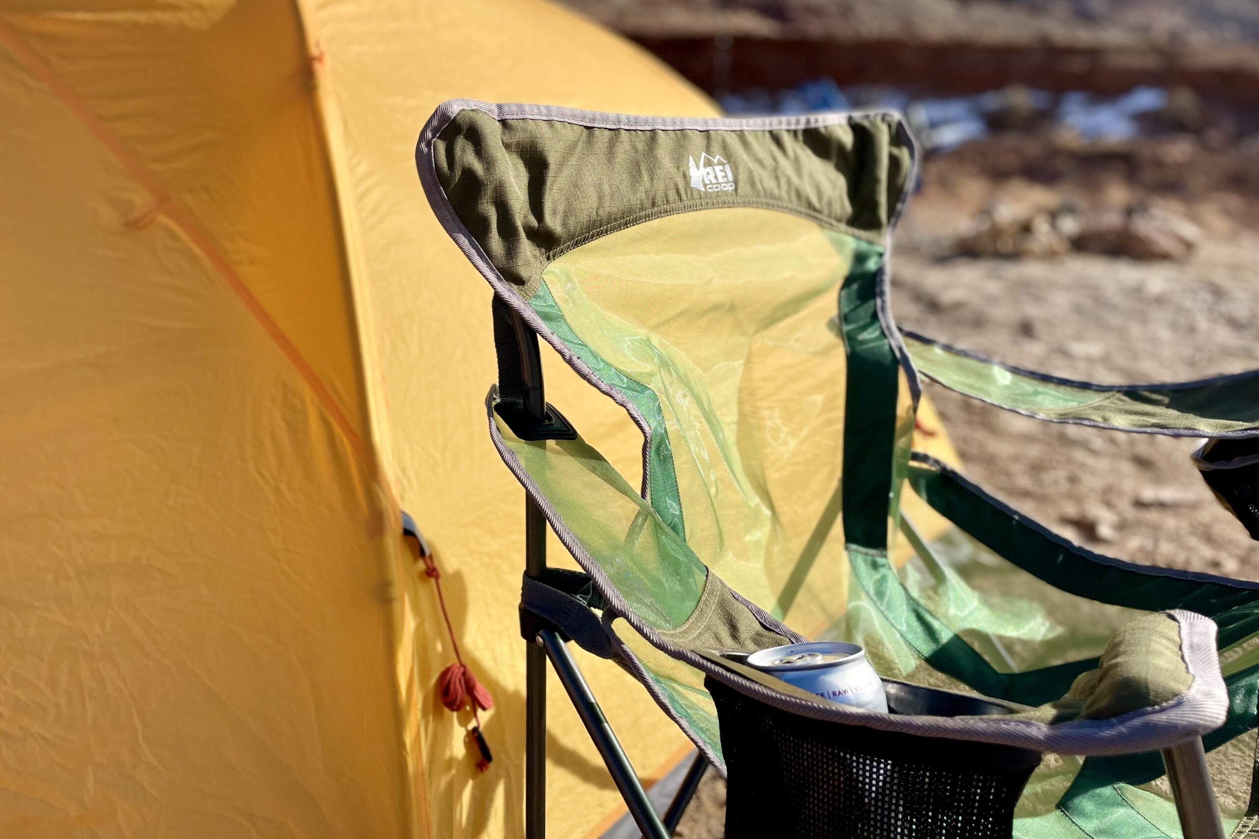Close up of a camping chair in the desert in front of a tent.