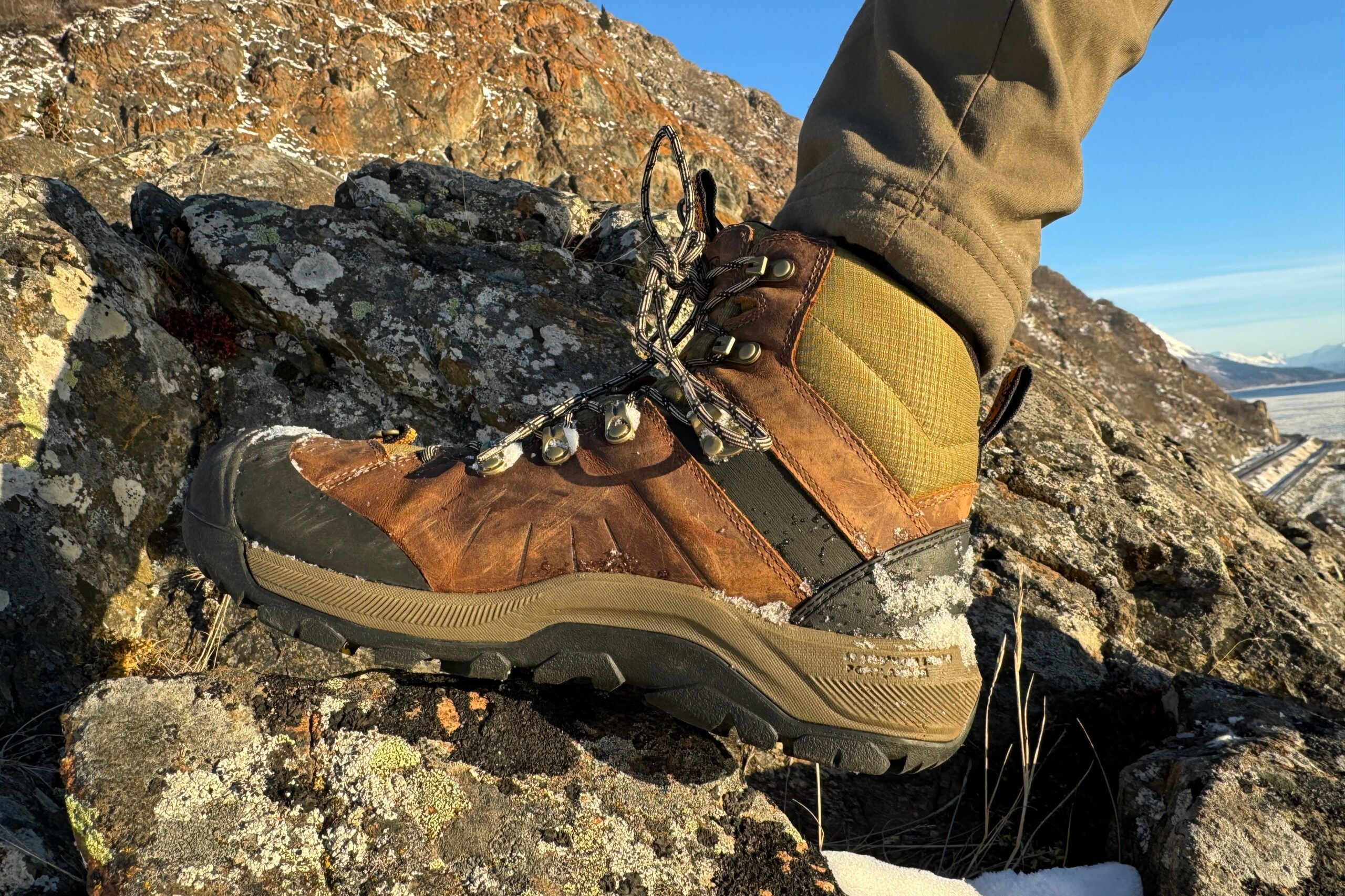 A closeup of the instep of a pair of boots showing wear.