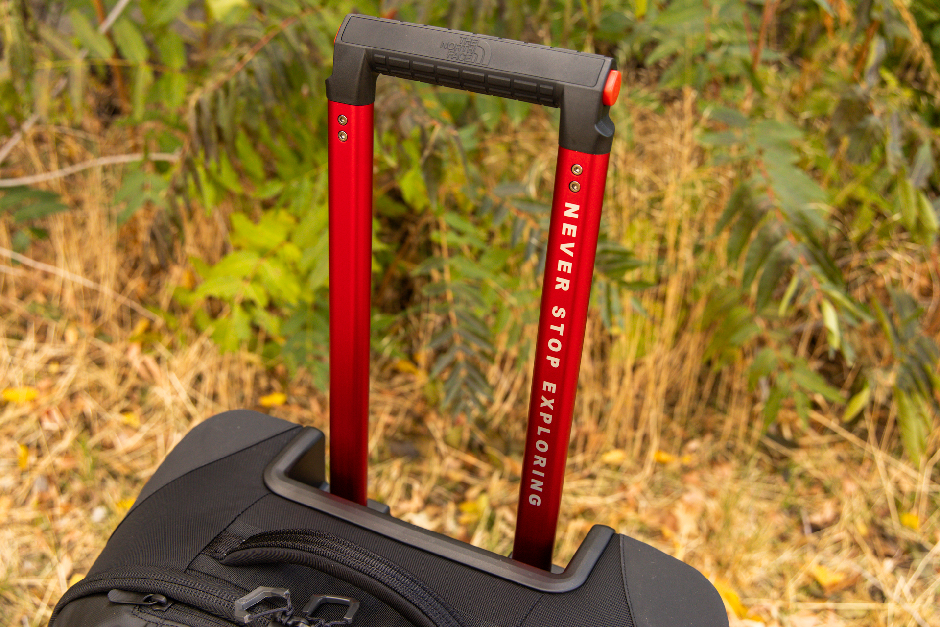 The extendable red handle extended with a red push-button release on the side.