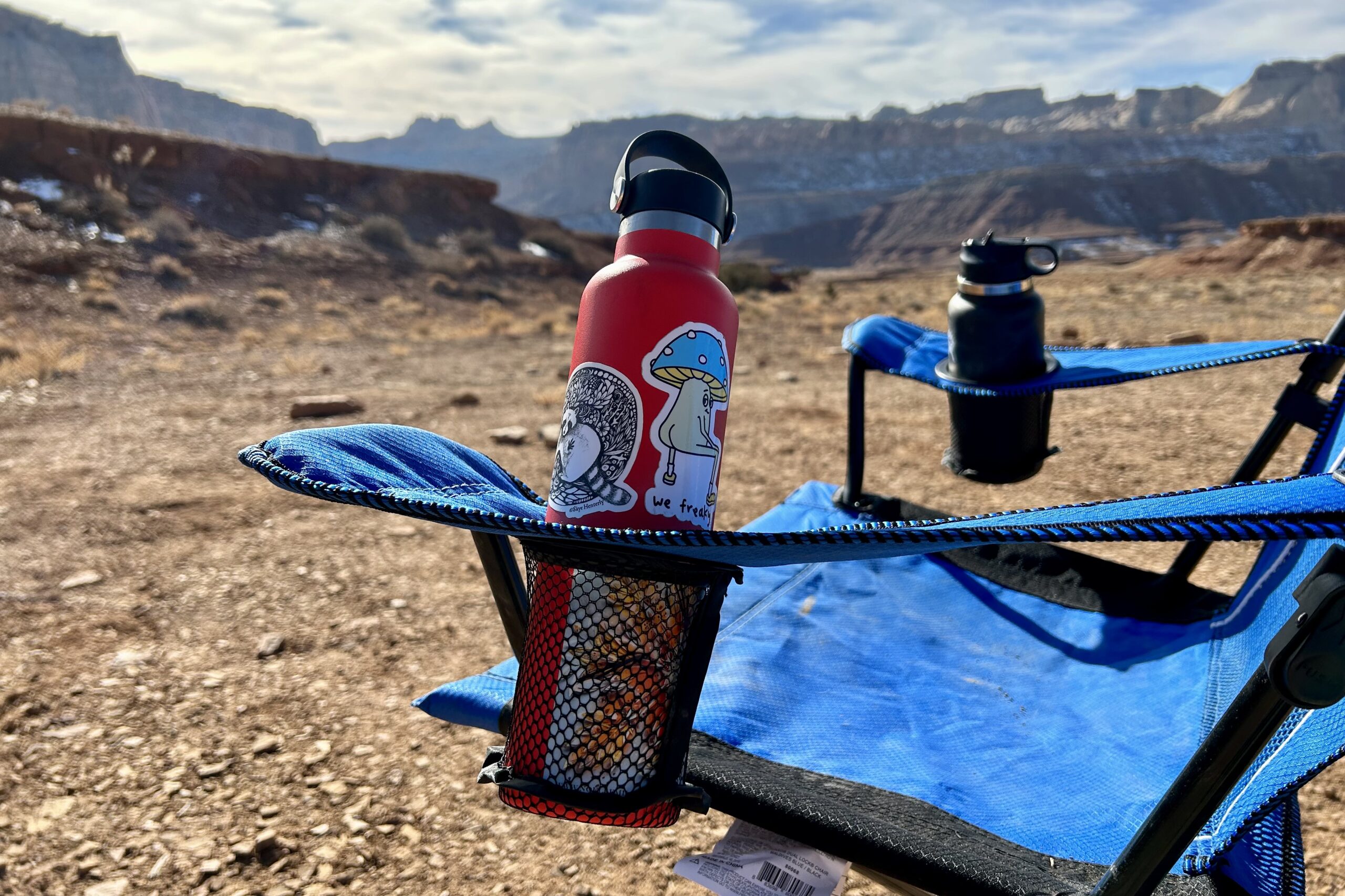 Close up of a chair's cupholders with water bottles in them.