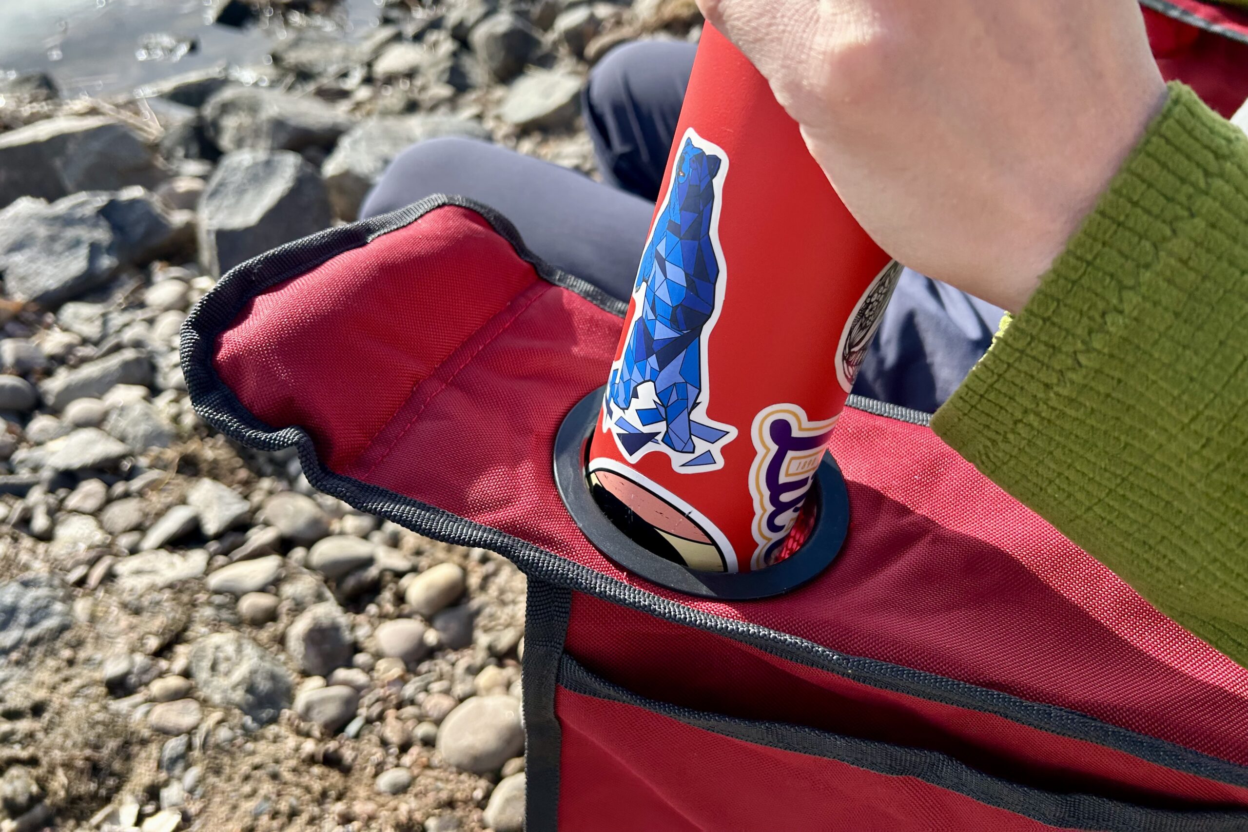 Close up of a person putting a water bottle into a cupholder.