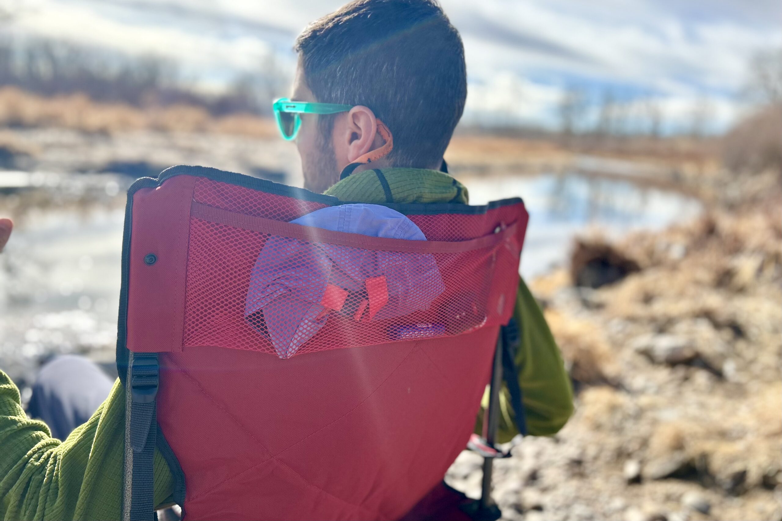 Close up of the back of a man's head and the back of a camping chair.