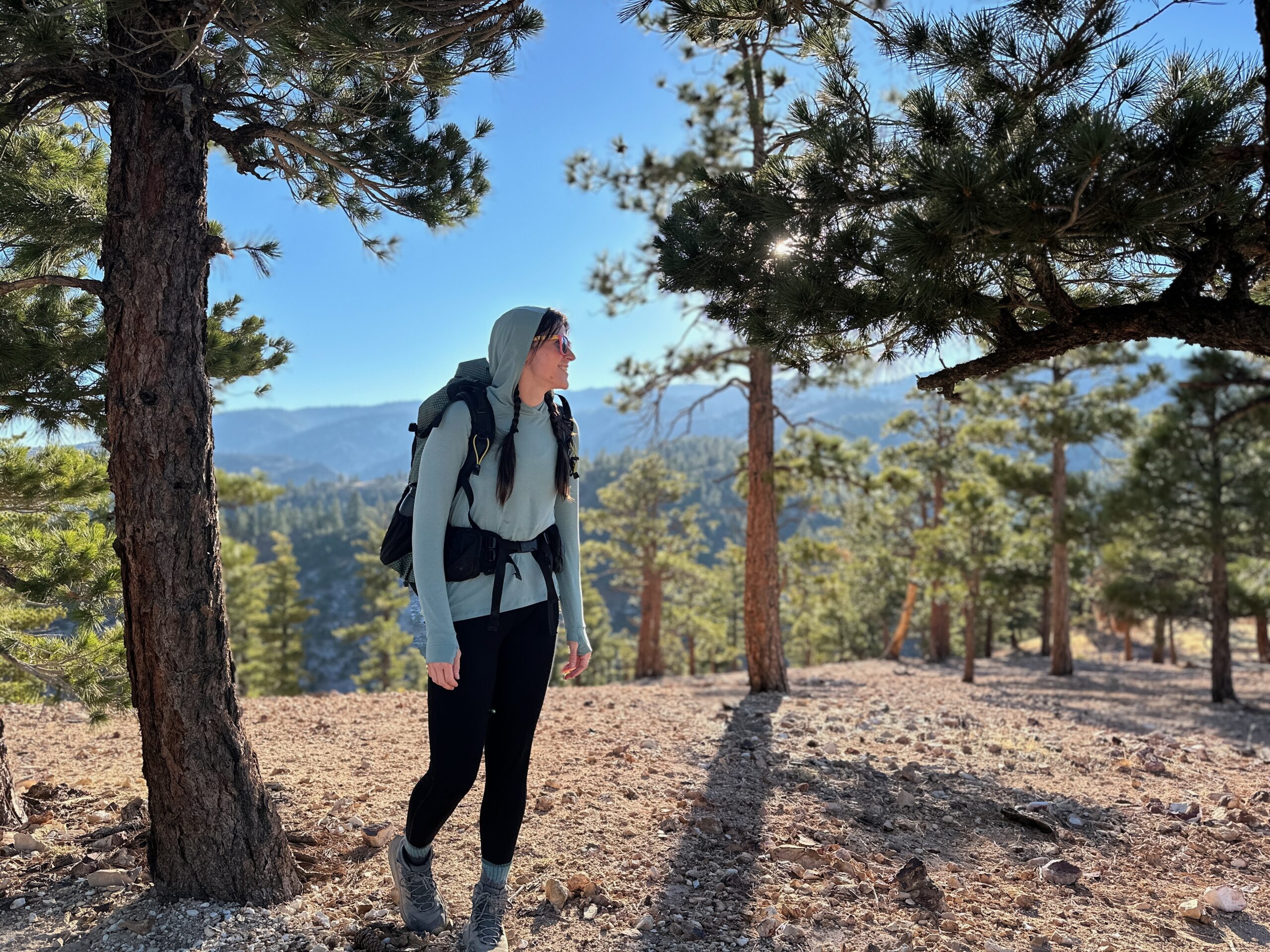 woman hiking with backpacking pack on in pine forest