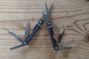 The Leatherman Micra on a board with its tools deployed.