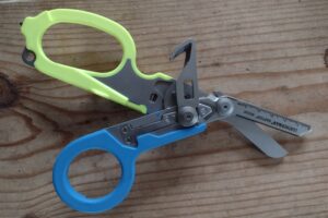 The Leatherman Raptor with blue and yellow handles and its tools deployed.