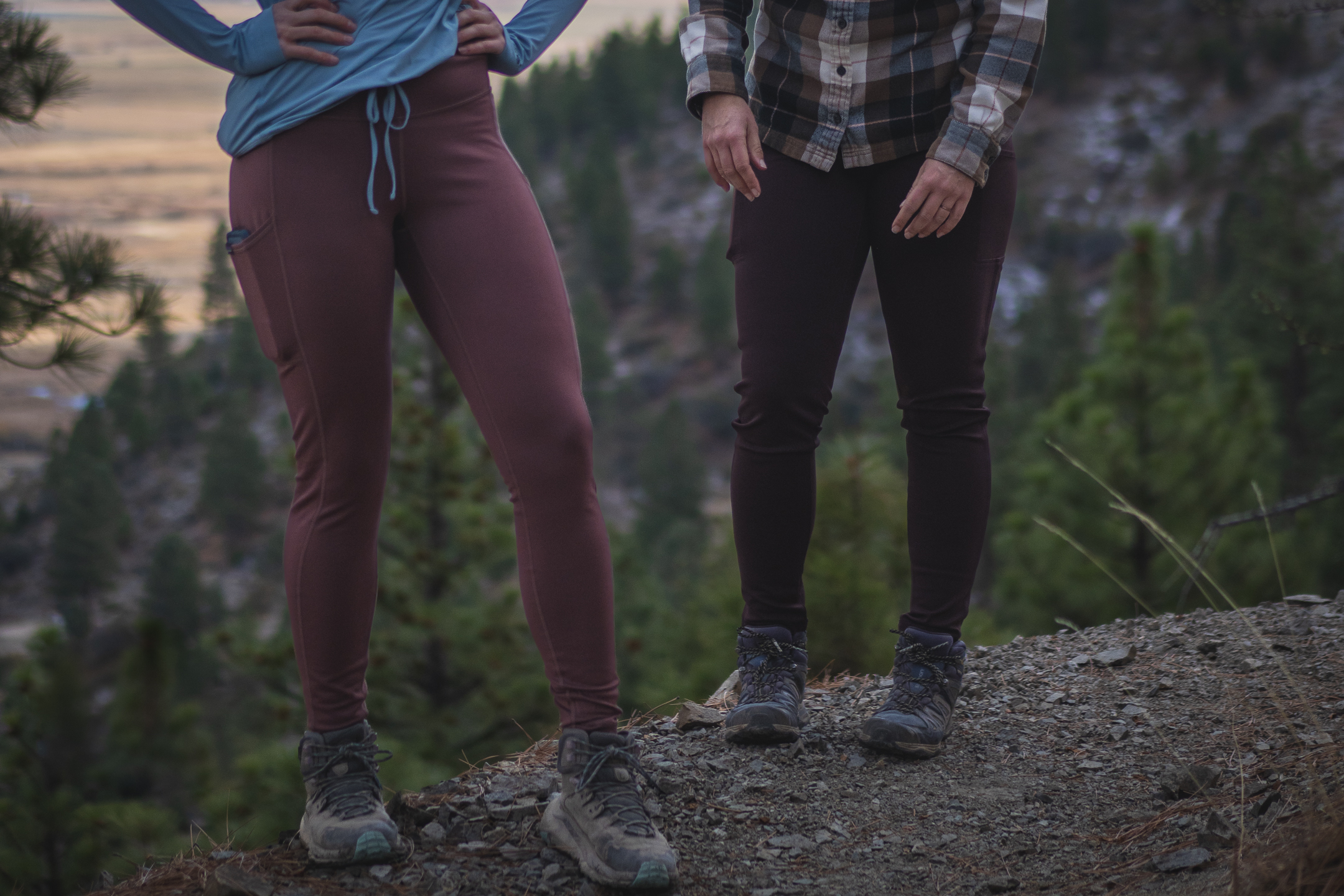 Two people on hiking rail, one in pastel pink leggings and another in dark brown leggings.