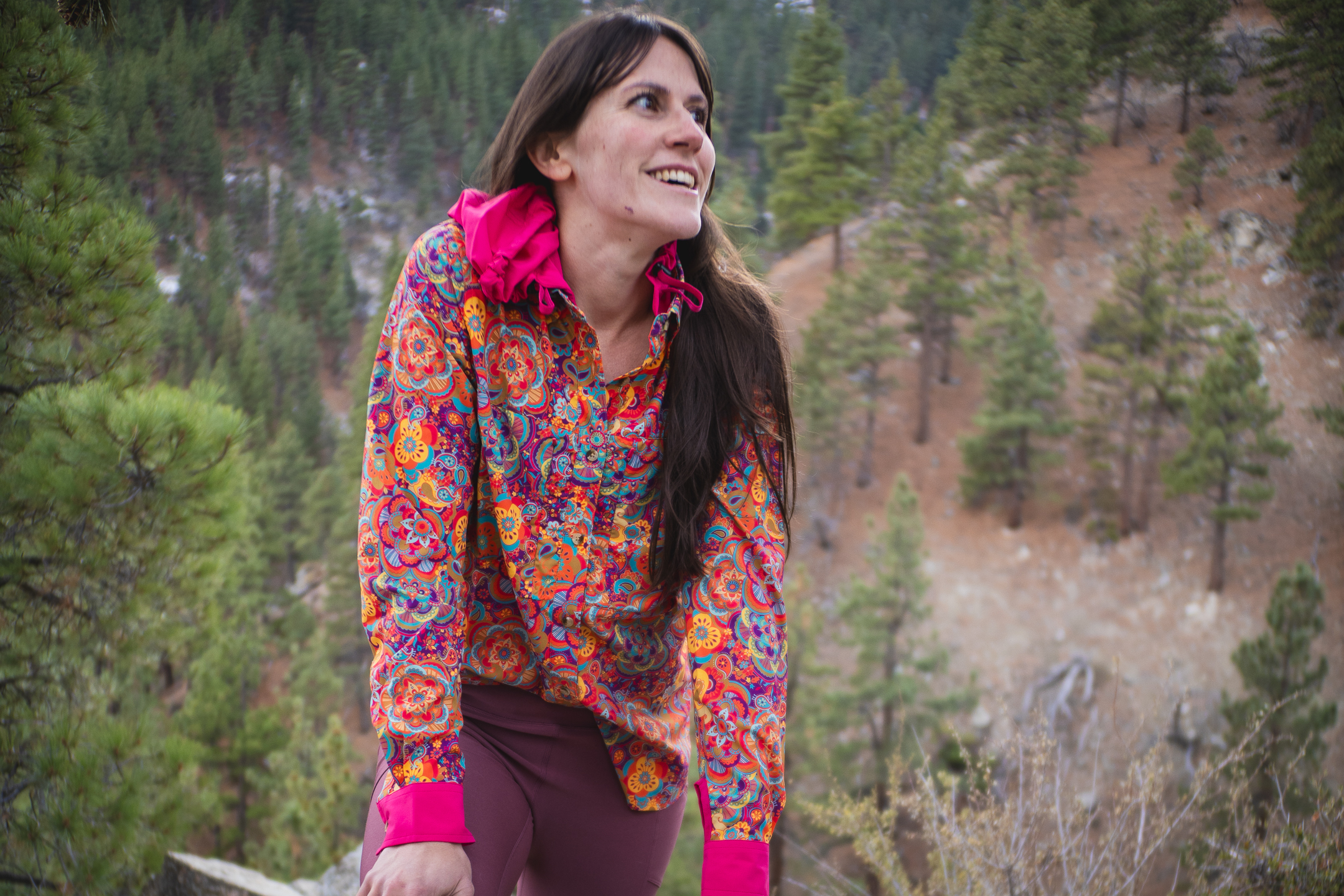 woman hiking with colorful shirt in pine forest