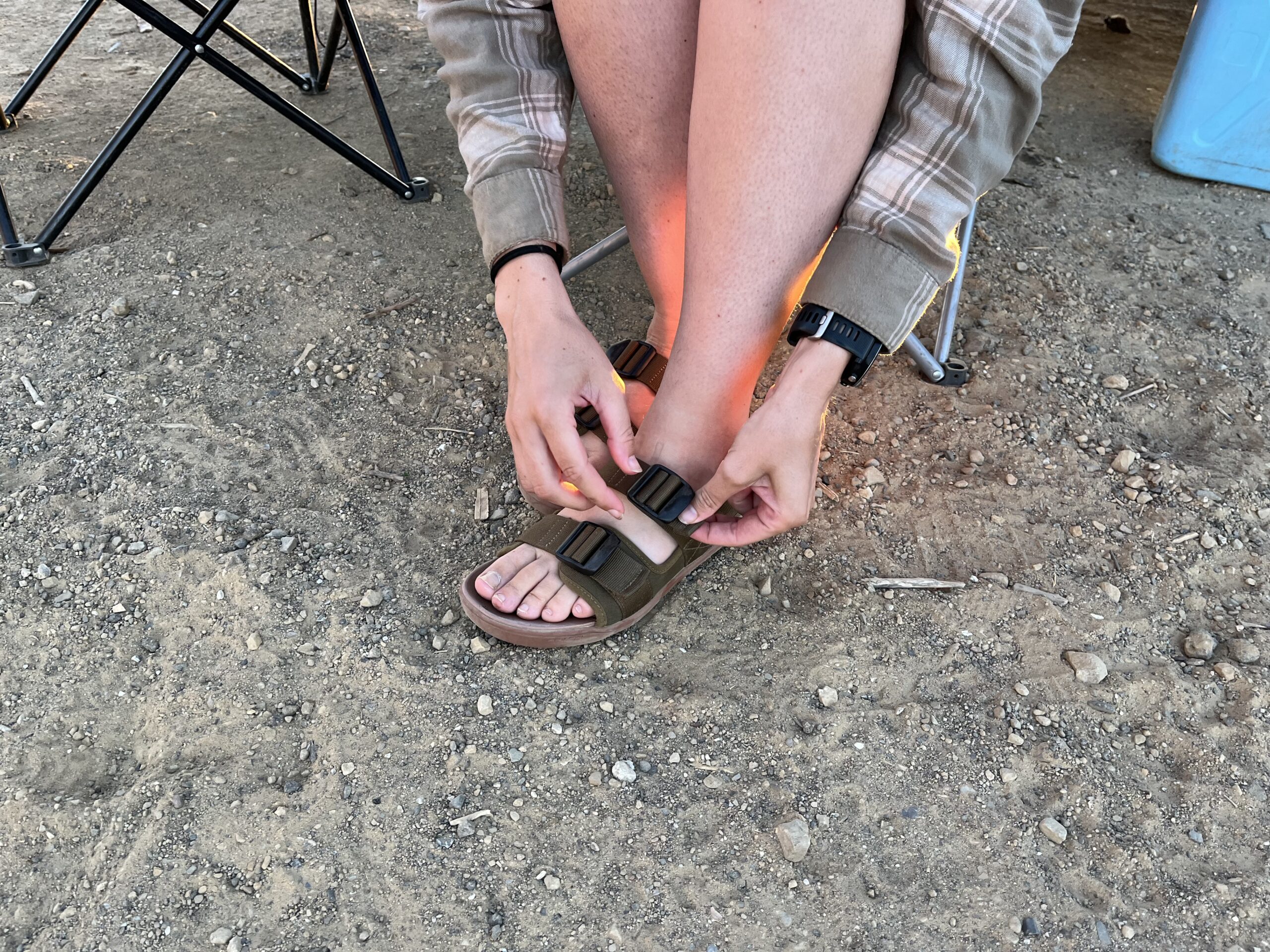 Our tester adjusting the strap of the Astral Webber hiking sandal.