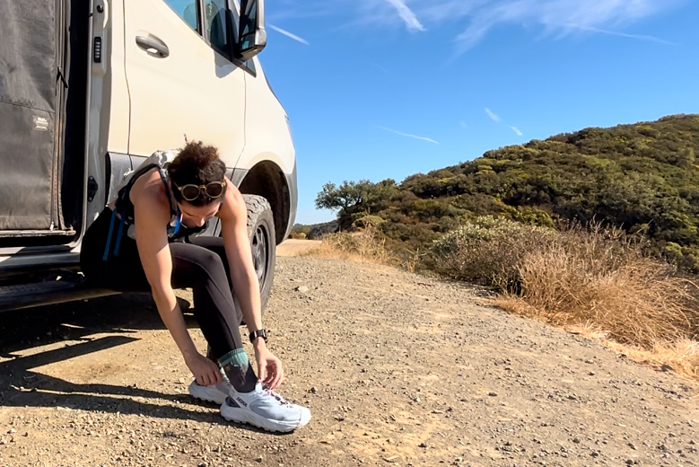 Our tester putting on the HOKA Hopara 2 sandals on a hike.