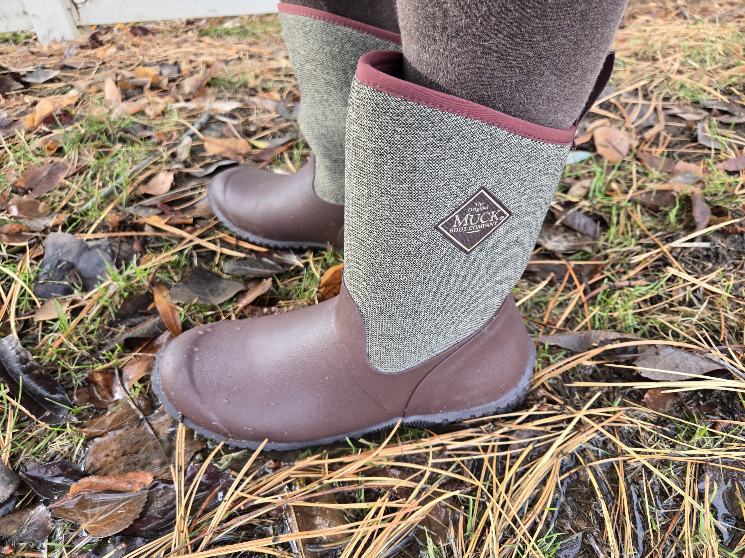 Side view of the Muckster II rain boot standing on wet leaves.