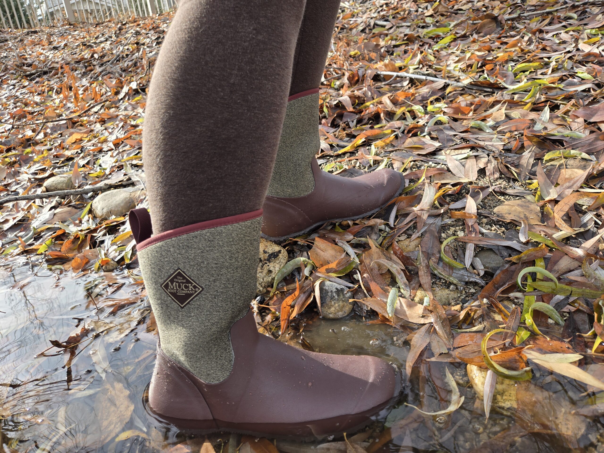 Side view of the Muckster II rain boot as someone steps out of a puddle.
