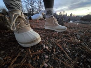 a woman wearing the sorel out-n-about IV's on bare ground