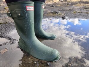 a close up of the hunter original short boot in a puddle
