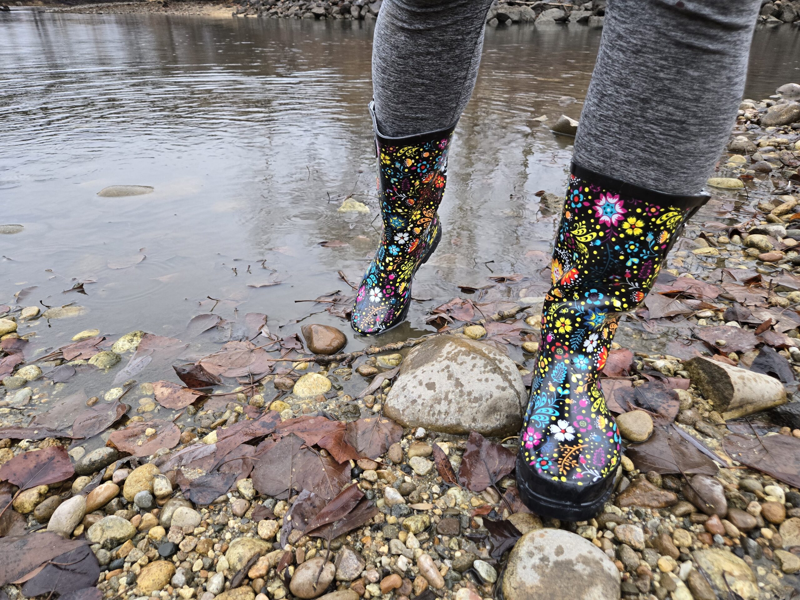 a person walking on the edge of a pond in the western chief garden play rain boots