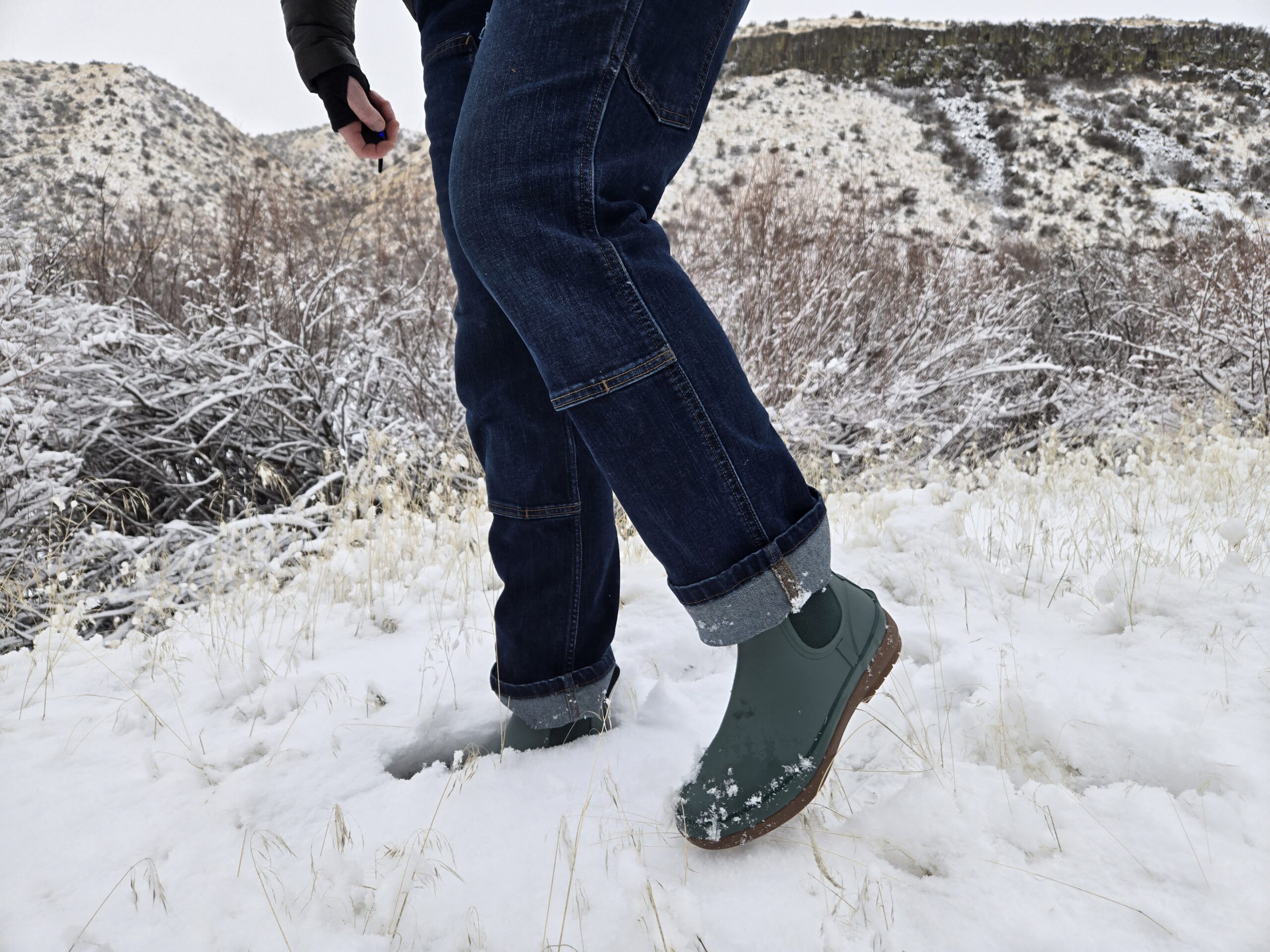 view of a woman's legs wearing the bogs amanda chelsea boot in some light snow