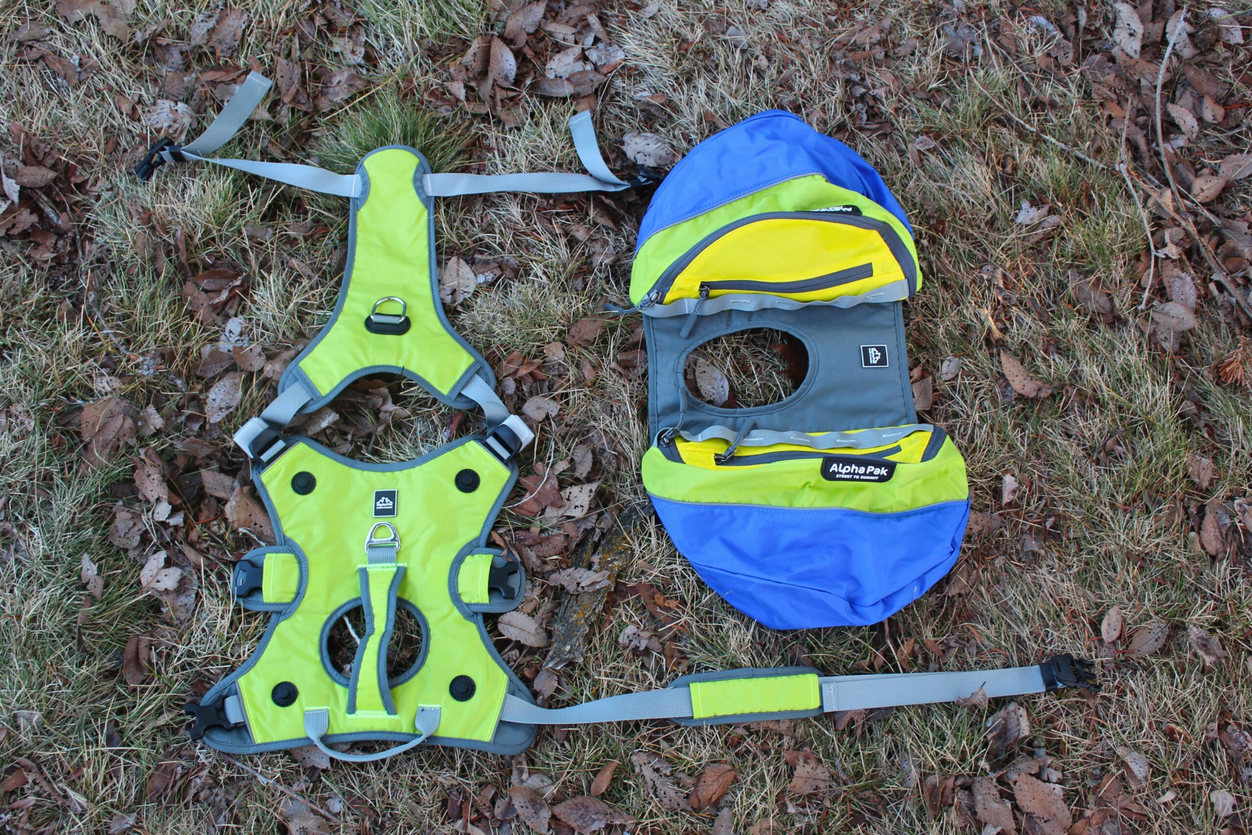 The AlphaPak Adventurer dog backpack laid out on the ground with the saddlebags detached from the harness.
