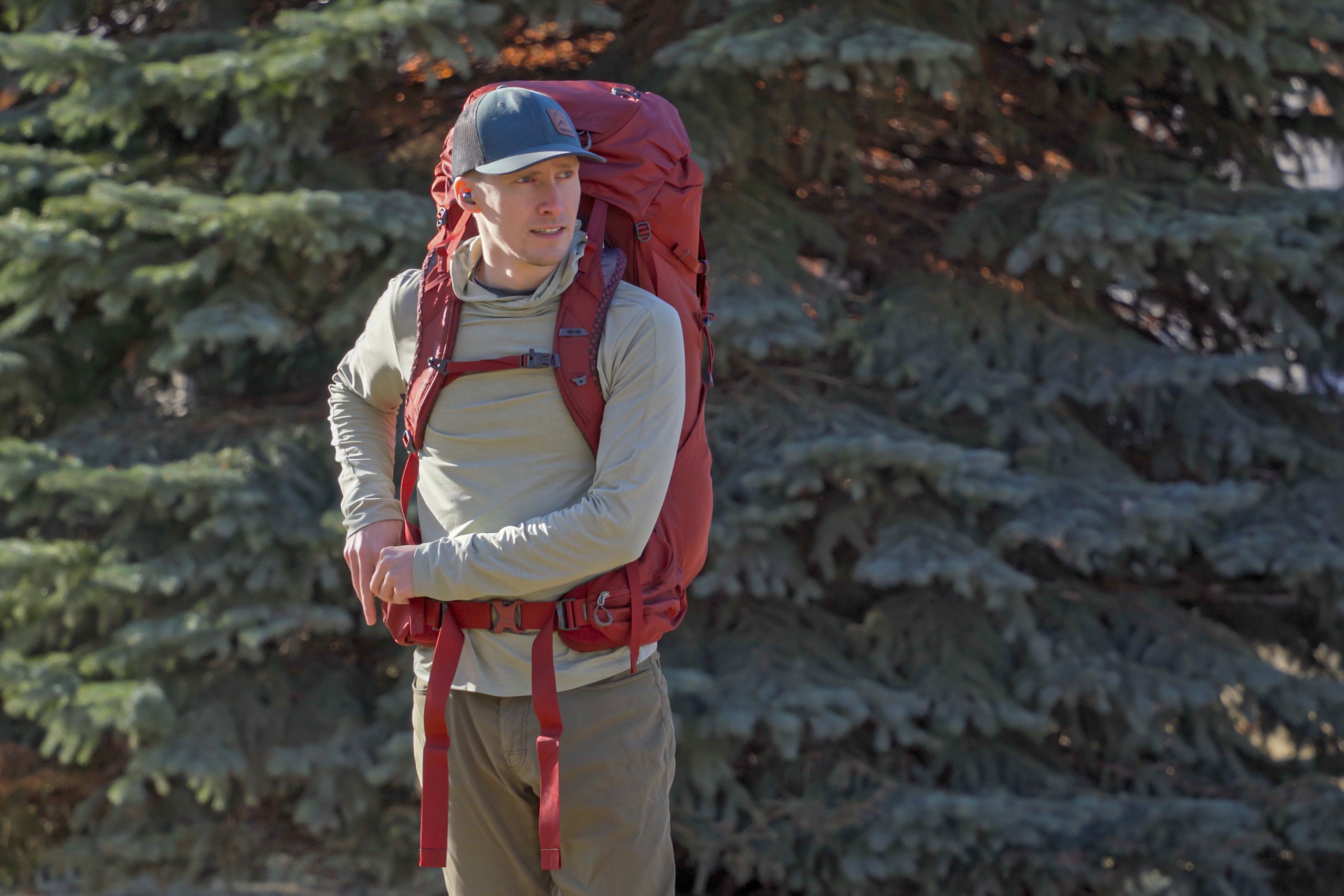 a man wears a red backpack