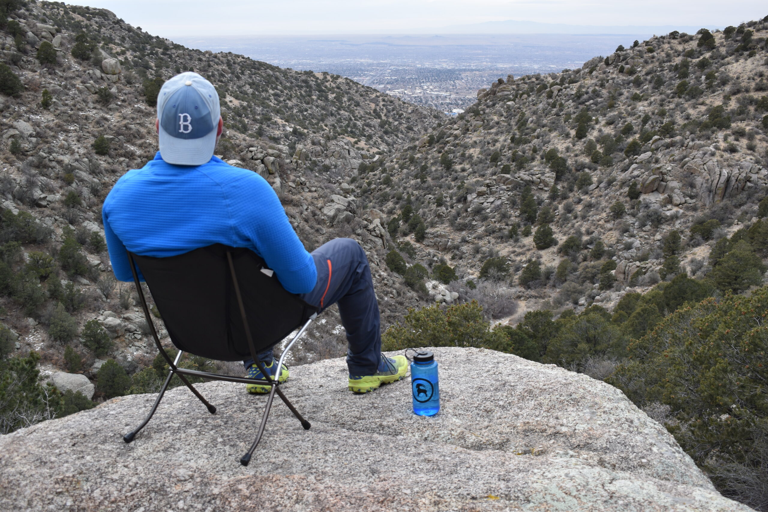 Hiker sitting on the Big Agnes chair in the foreground with a 50 mile view in the background of the New Mexico desert
