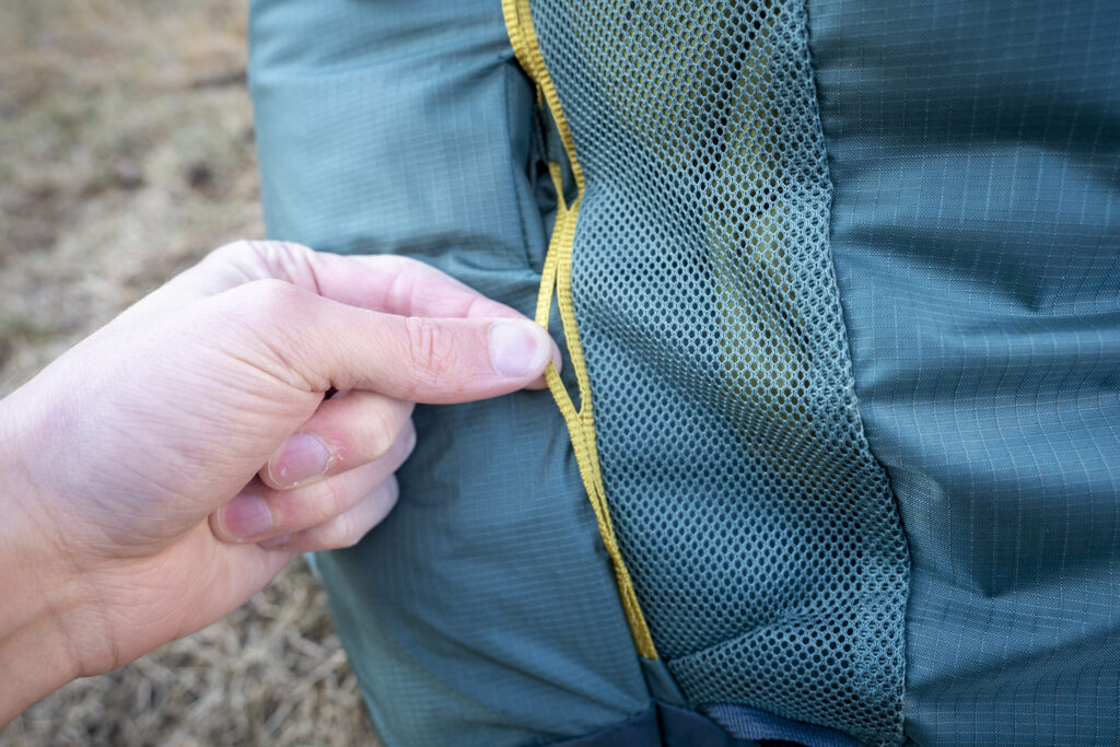a hand holds a strap on a backpack