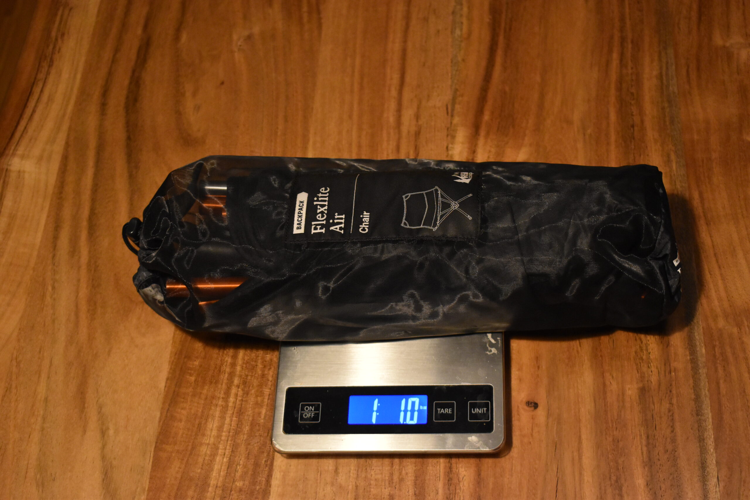 REI Flexlite Air Chair packed and sitting on a kitchen scale that reads 1 lb 1 oz