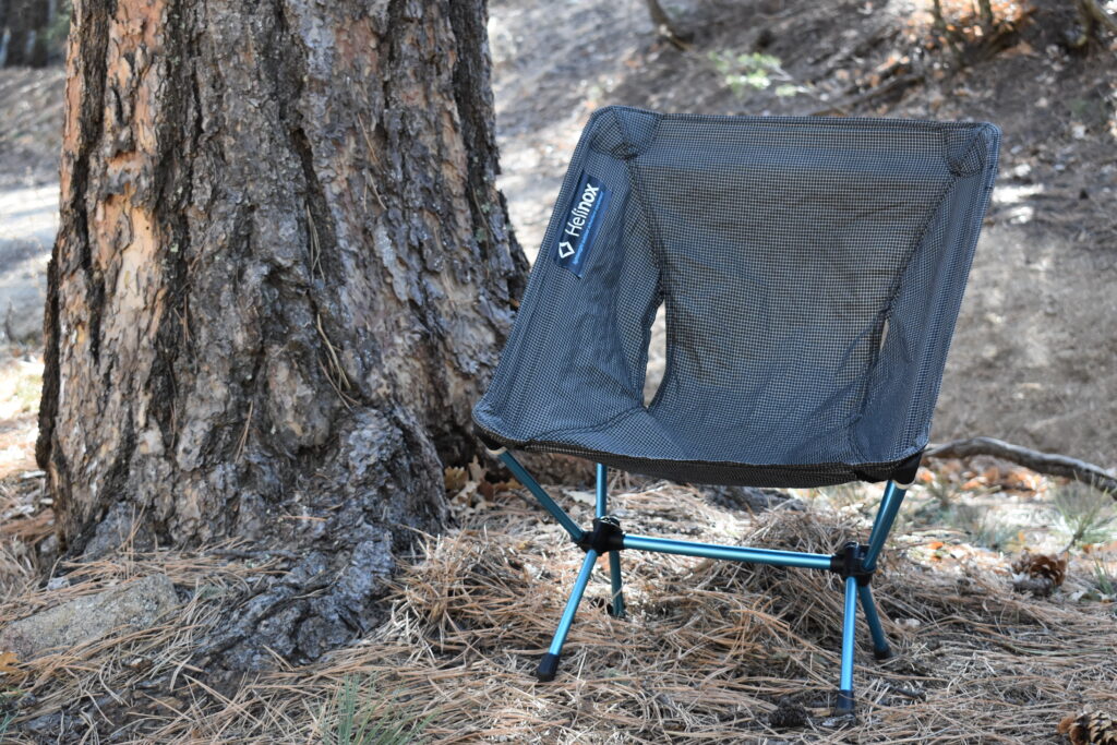 Helinox Chair Zero set up next to a pine creek at a campsite