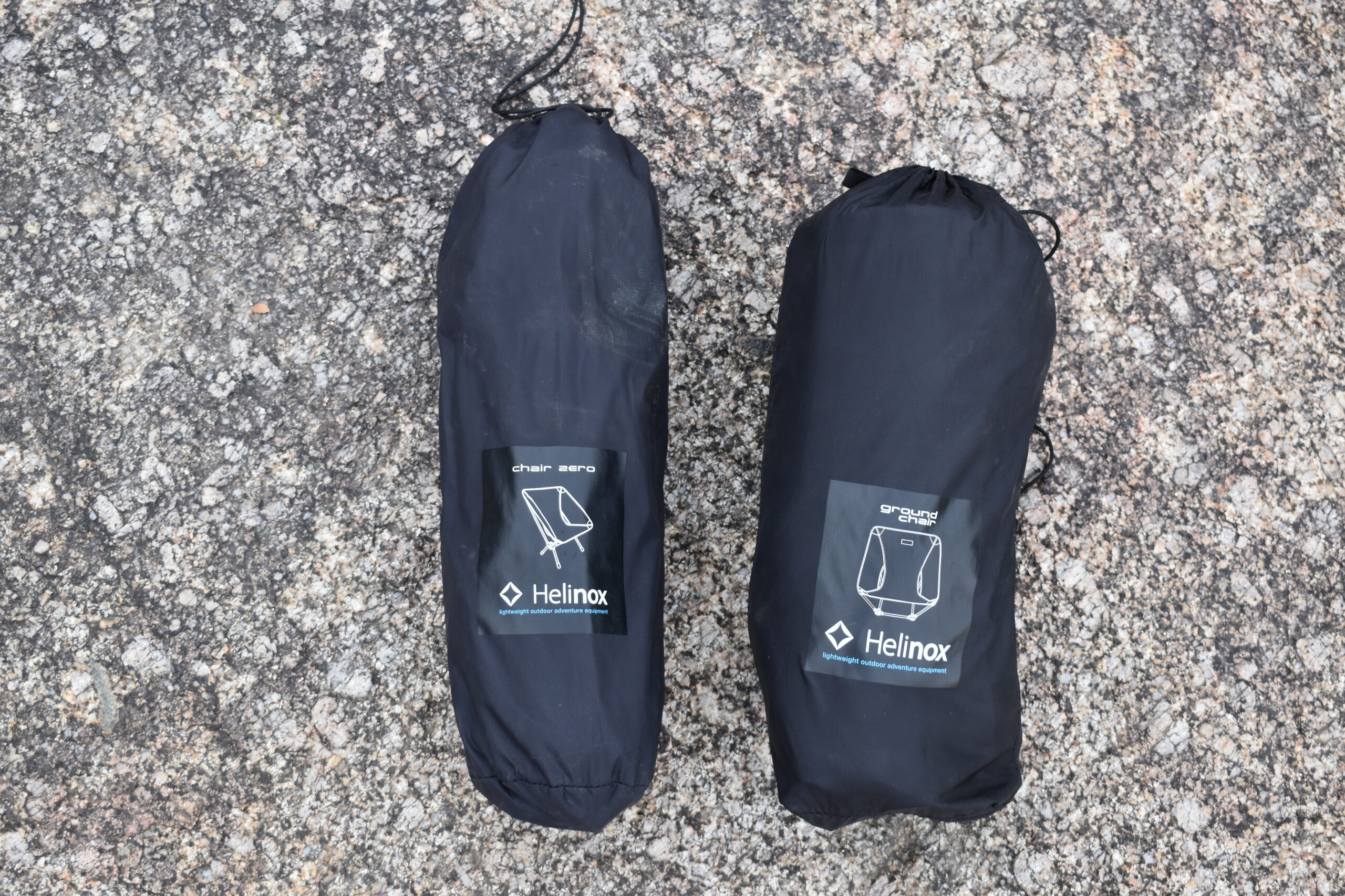 Two packed backpacking chairs side by side on a rock