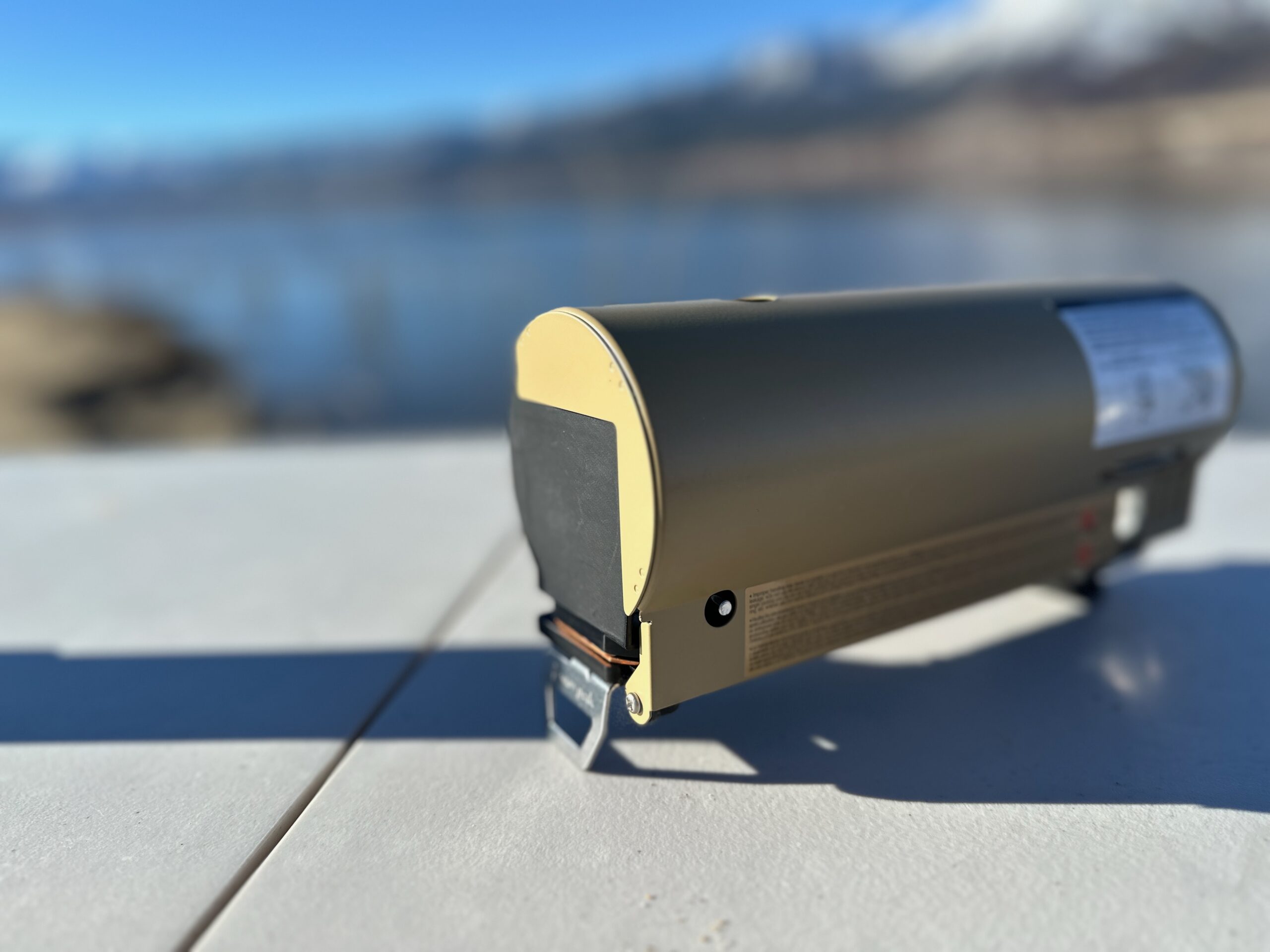 the Snow Peak Home & Camp butane stove folded up on a picnic table at the beach