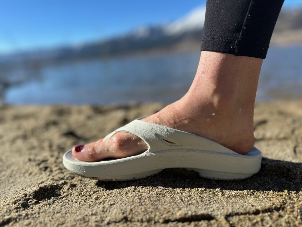 a woman wearing the OOfos OOriginals to show off the fit and support