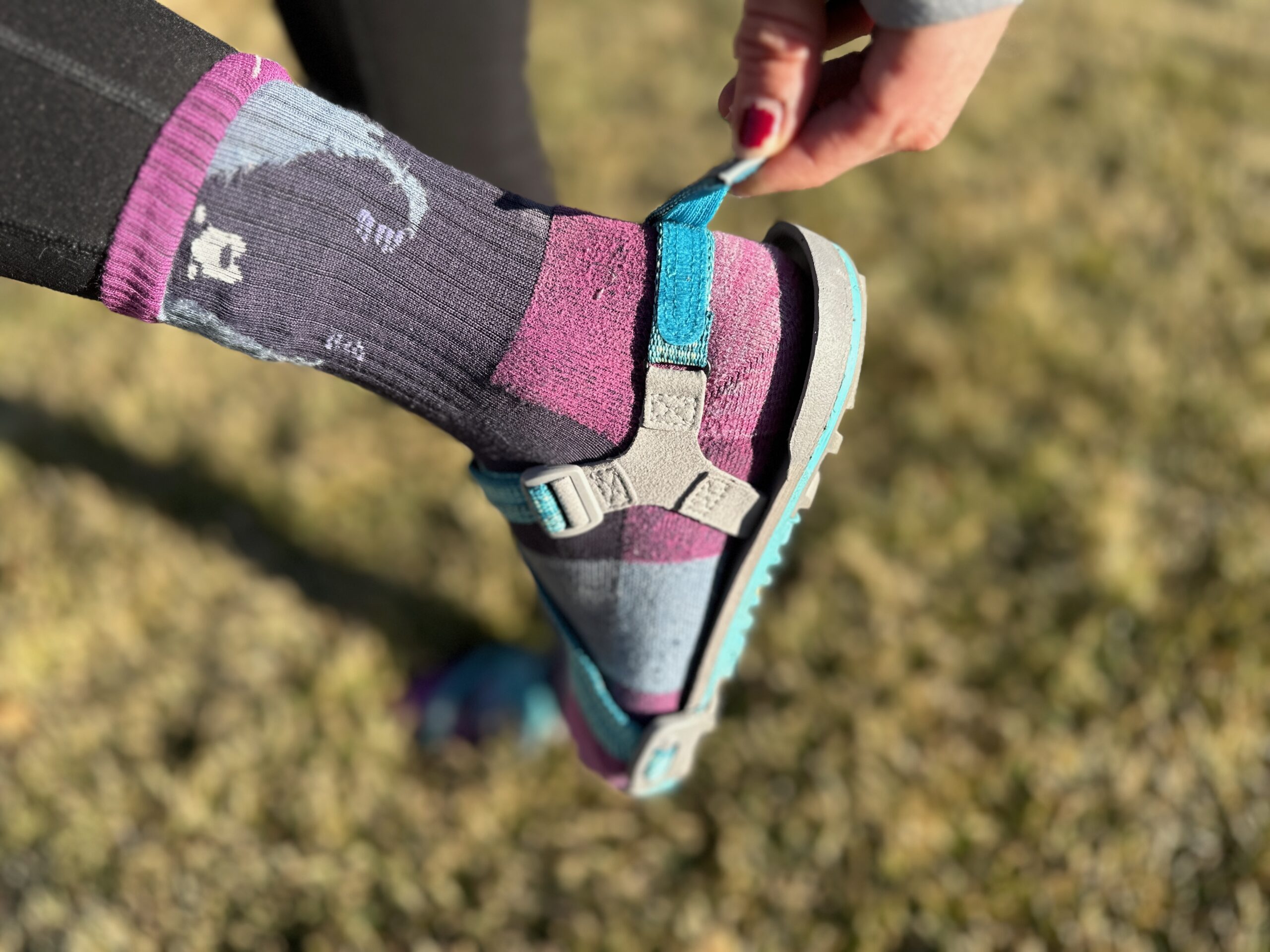 a woman wears the Xero Shoes Z-Trail EV on grass to show off the fit of the shoe