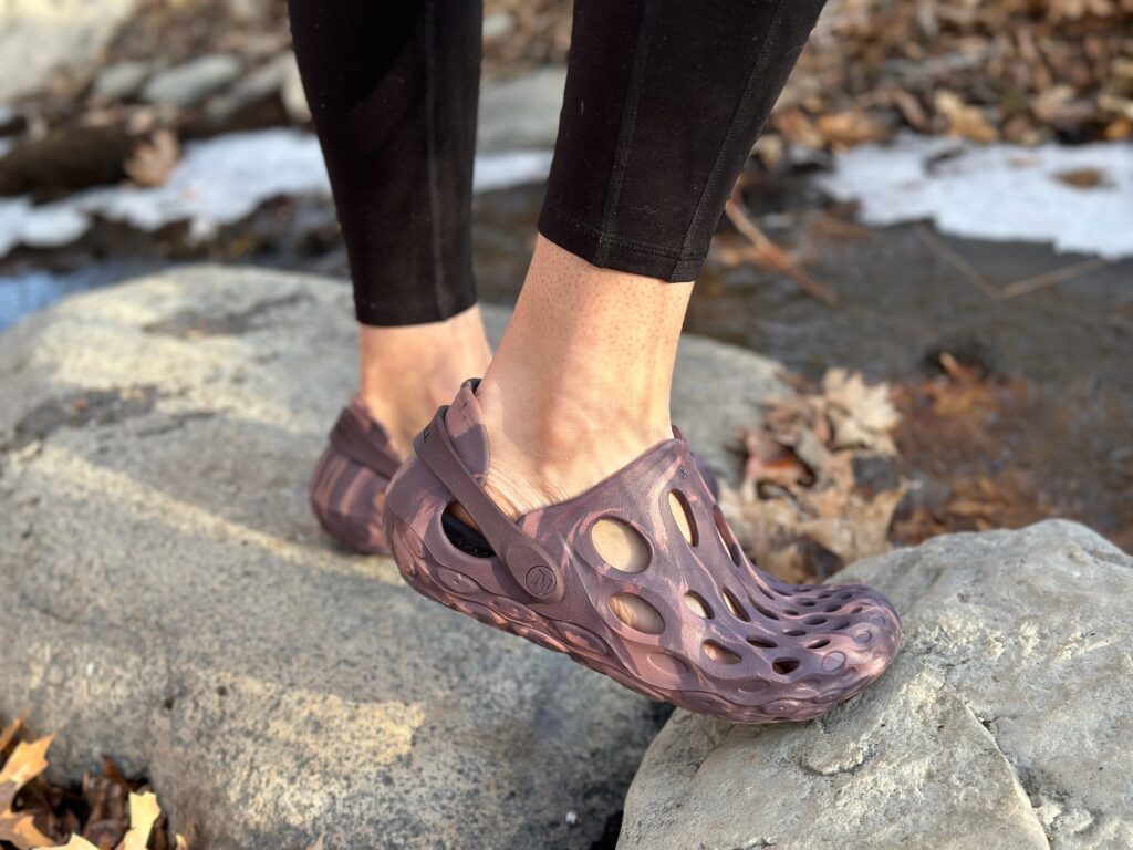 a woman wears Merrell Hydro Moc by a creek