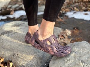 a woman wears Merrell Hydro Moc by a creek