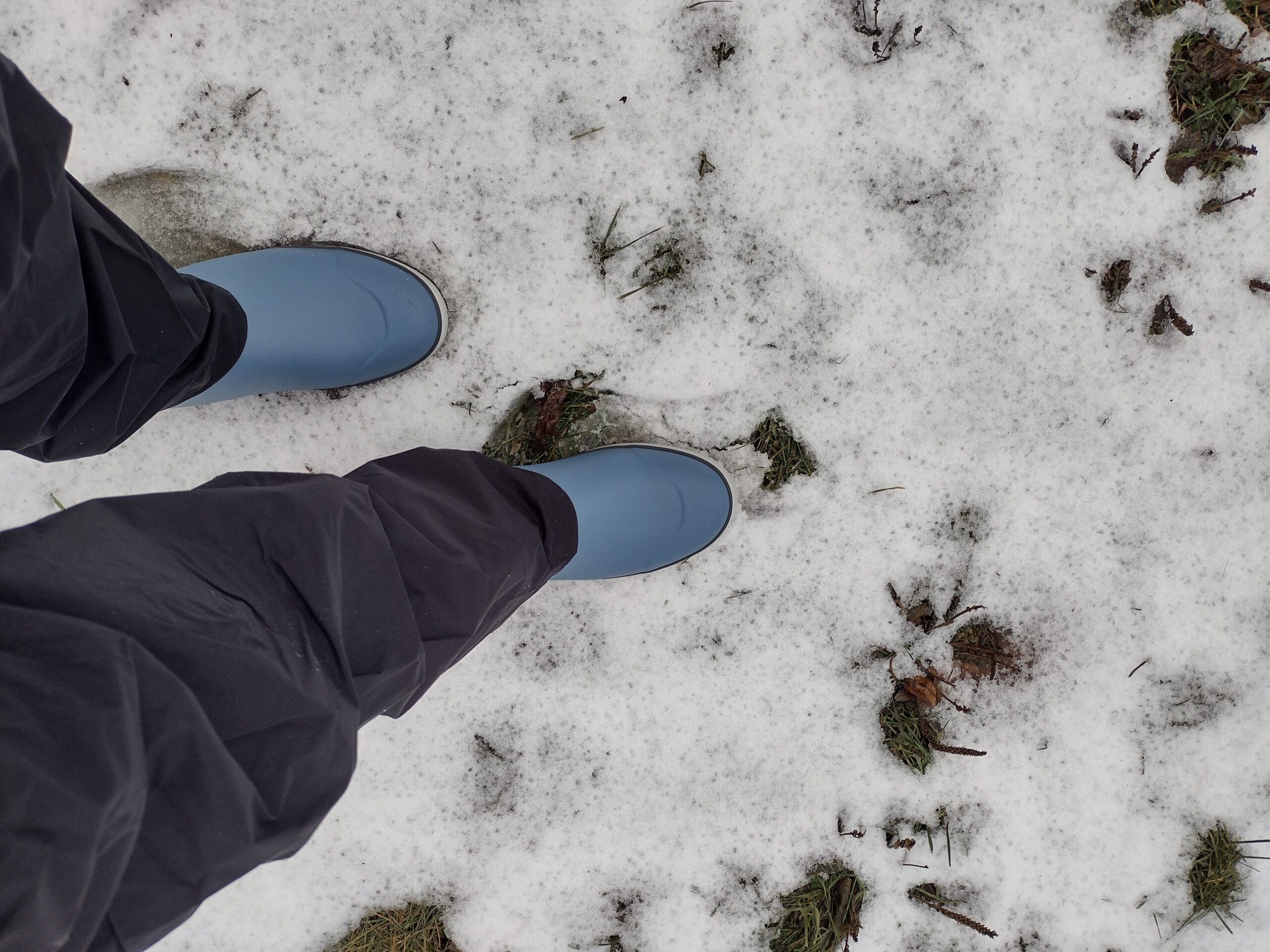Looking down at someone's feet wearing the light blue Huk Rogue Waves.