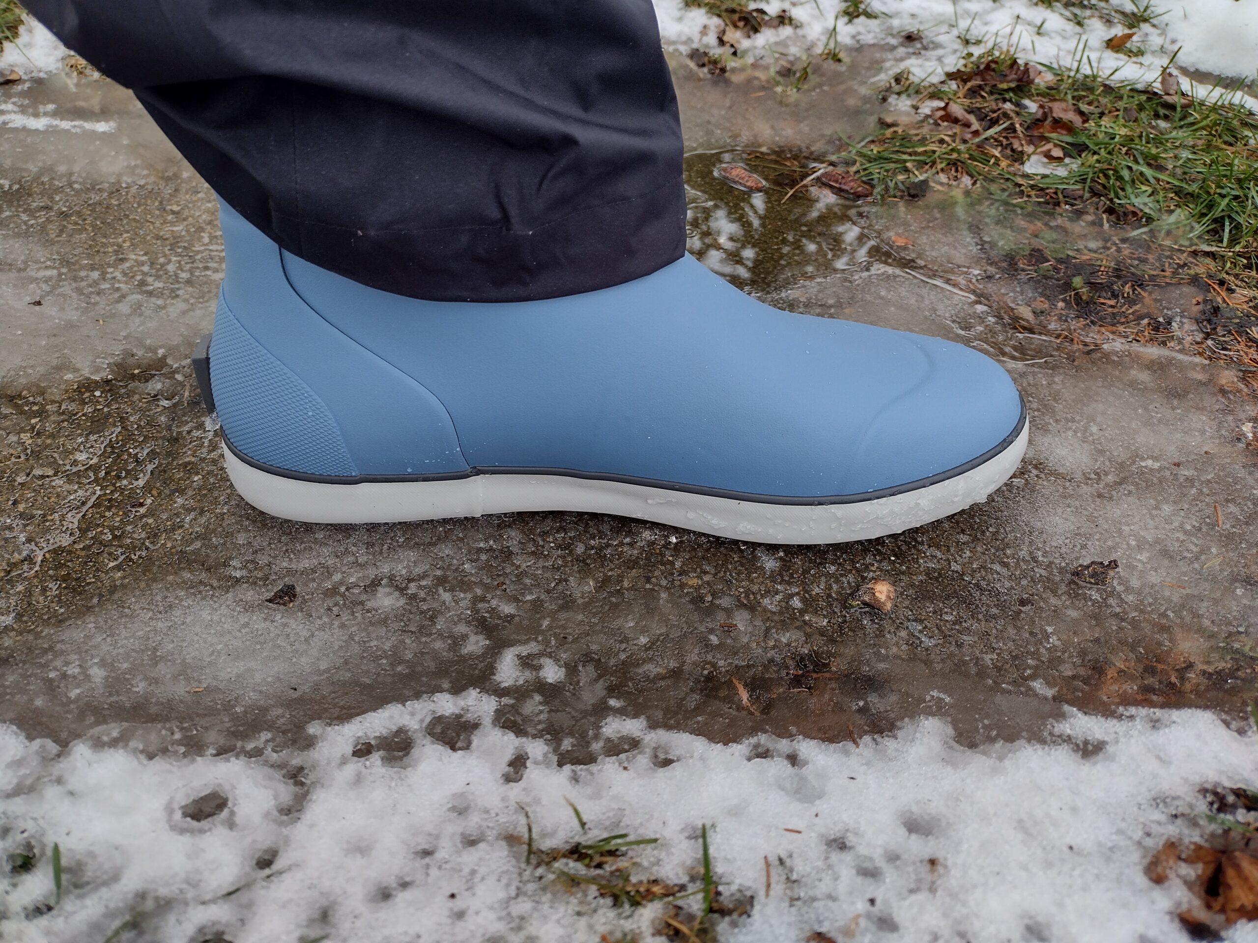 A ground level view of someone wearing the light blue Huk Rogue Wave boot.