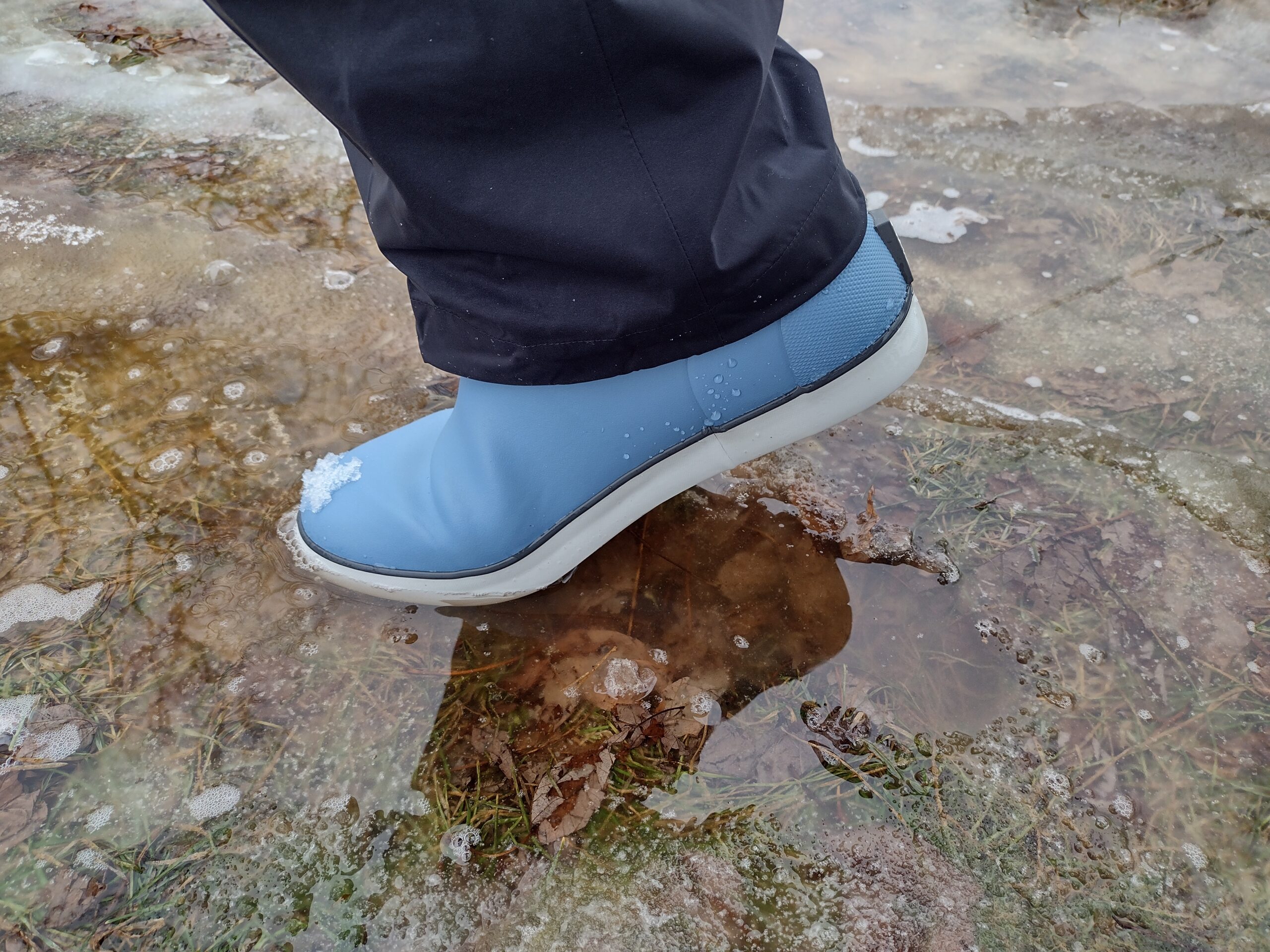 A ground level view of someone wearing the light blue Huk Rogue Wave boot.