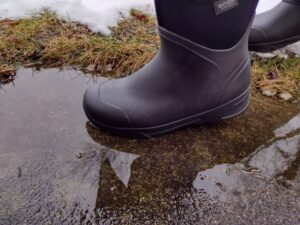 Ground level view of someone wearing the black Bozeman Mid boots.