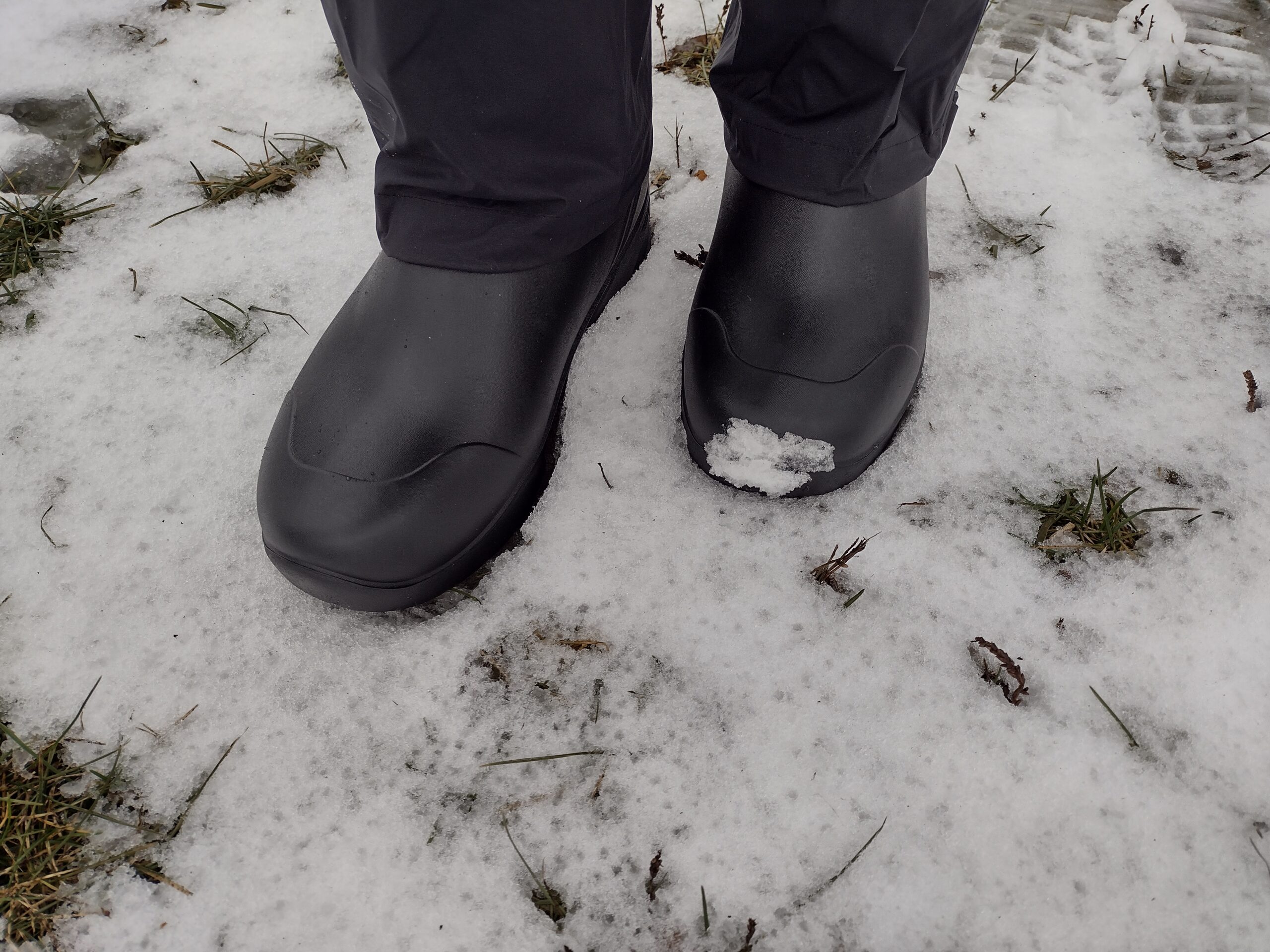 Ground level view of someone wearing the black Bozeman Mid boots.