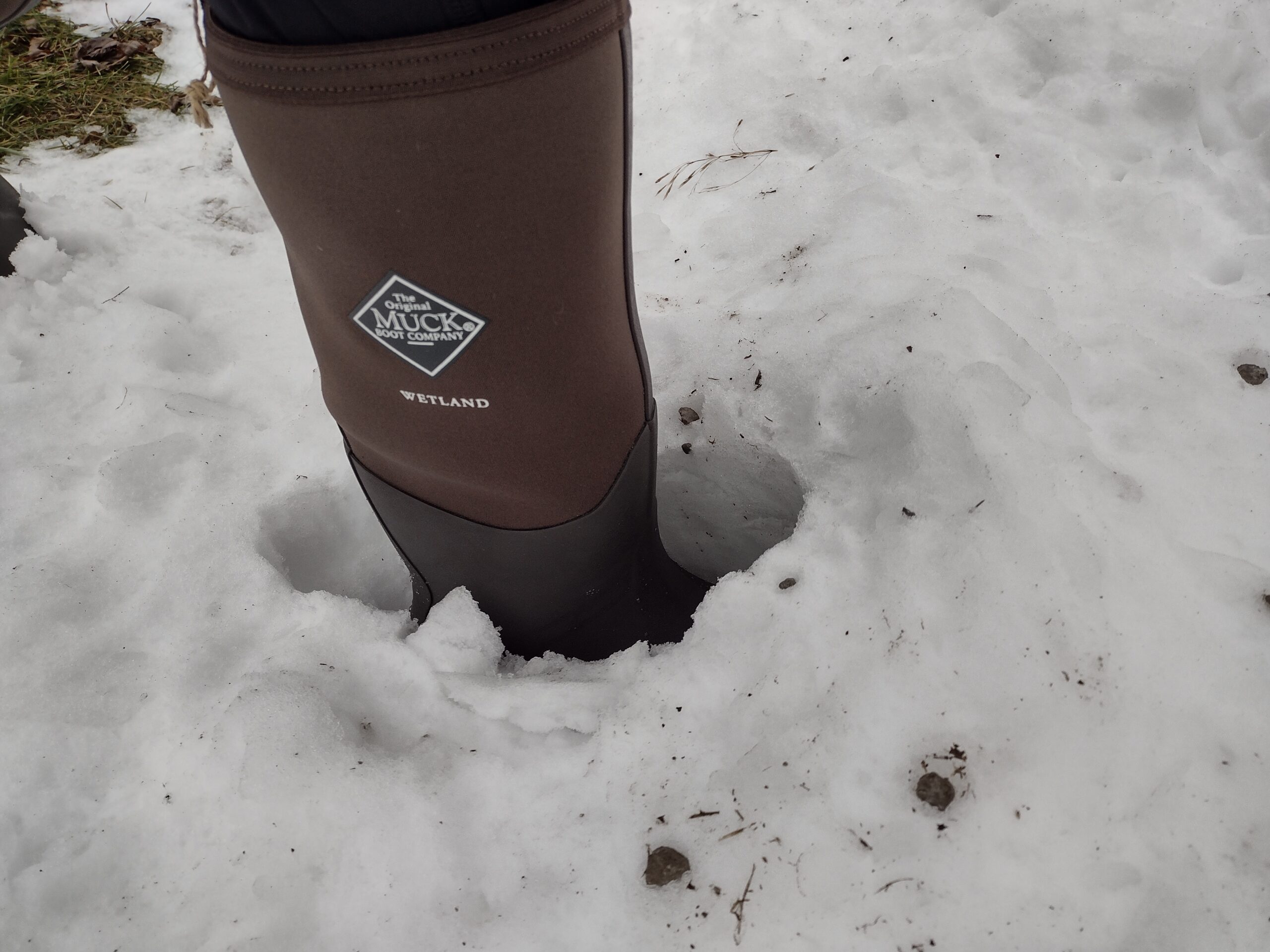 Ground level view of someone wearing the brown Original Muck Boot Wetland standing in deep snow.