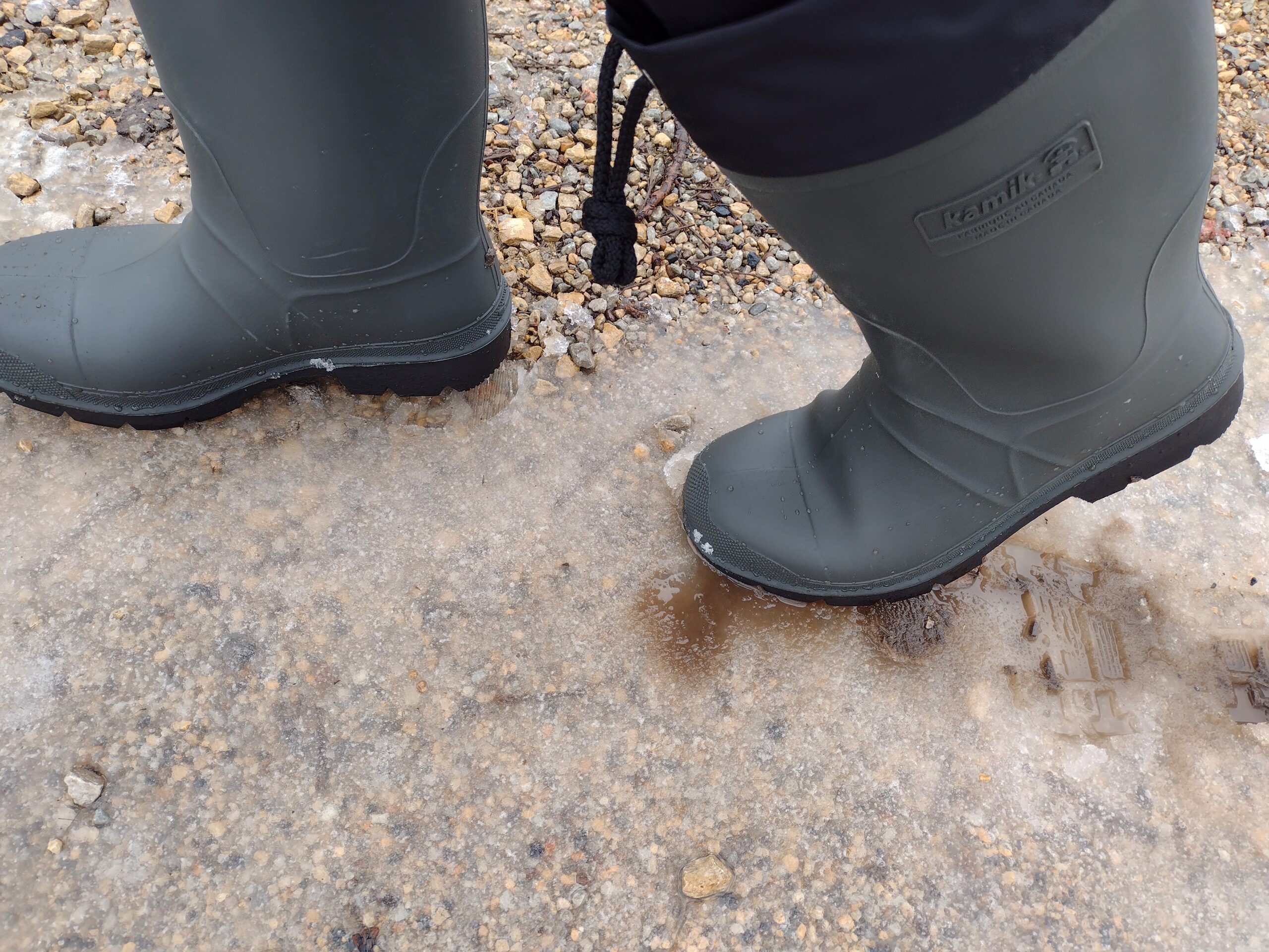 Ground level view of someone wearing the green Kamik Forester on ice.