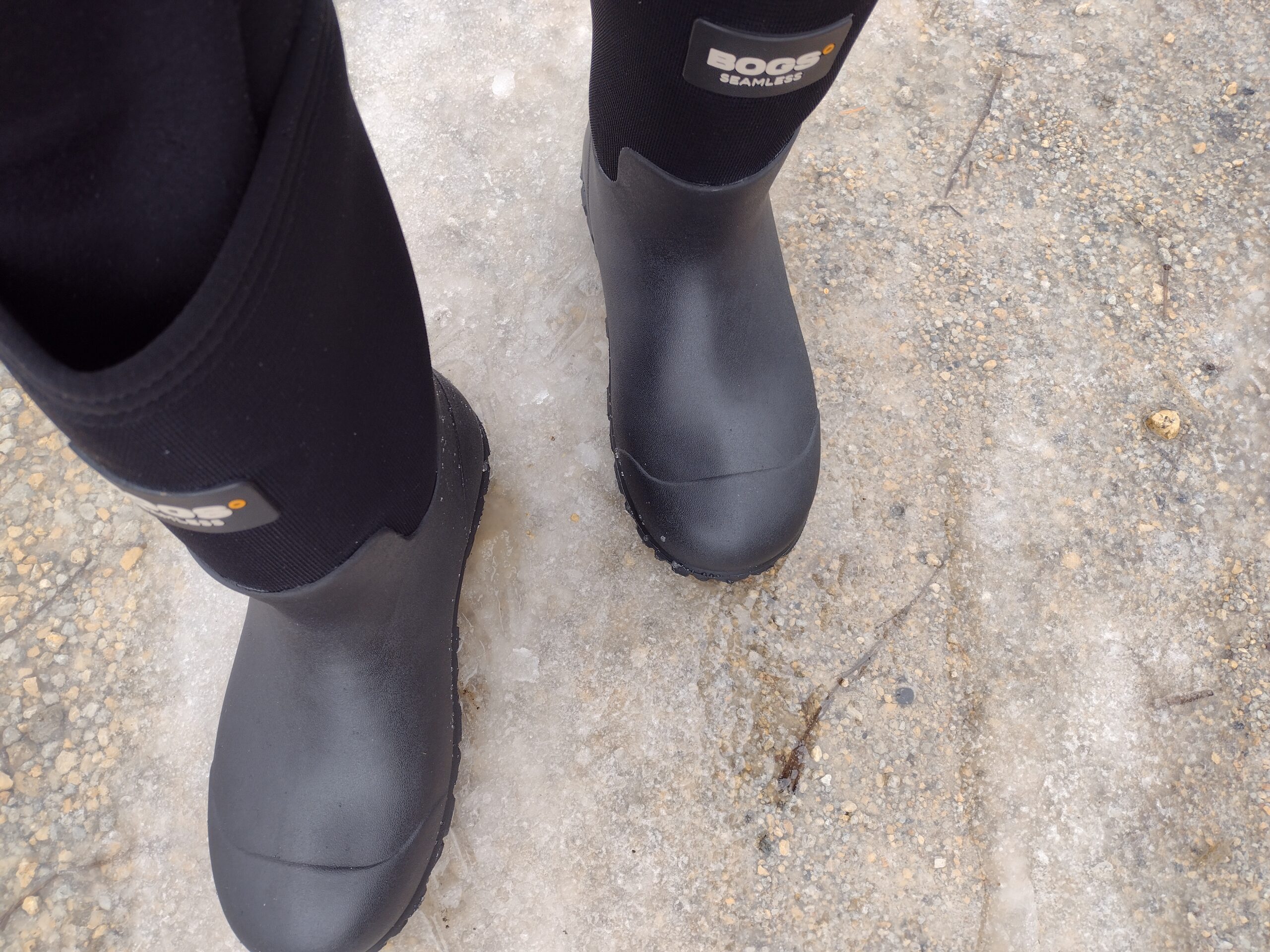 Ground level view of someone wearing the black Bogs Workman on ice.
