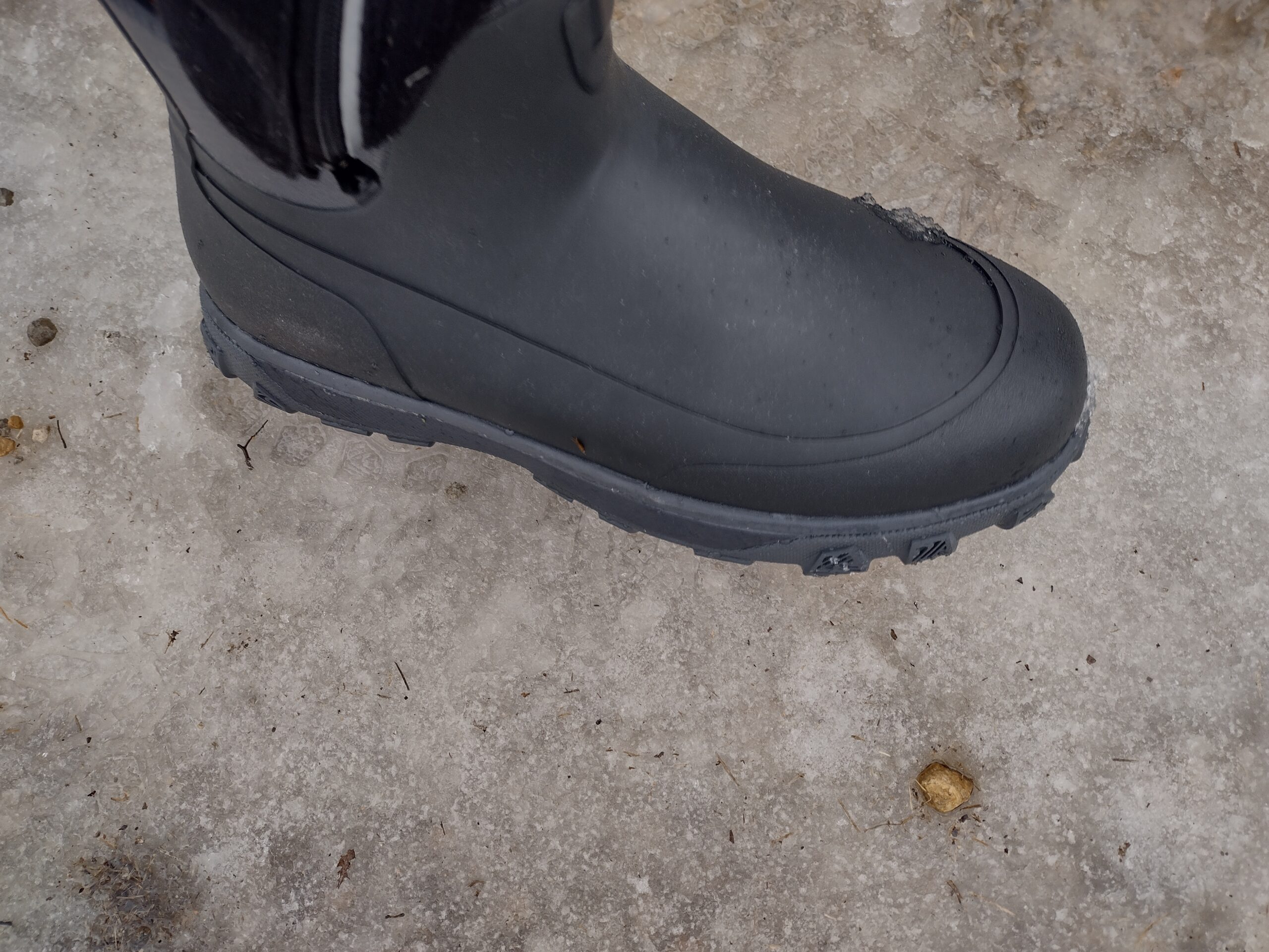 Ground level view of someone wearing the black Grundens Deviation Ankle Boot on ice.