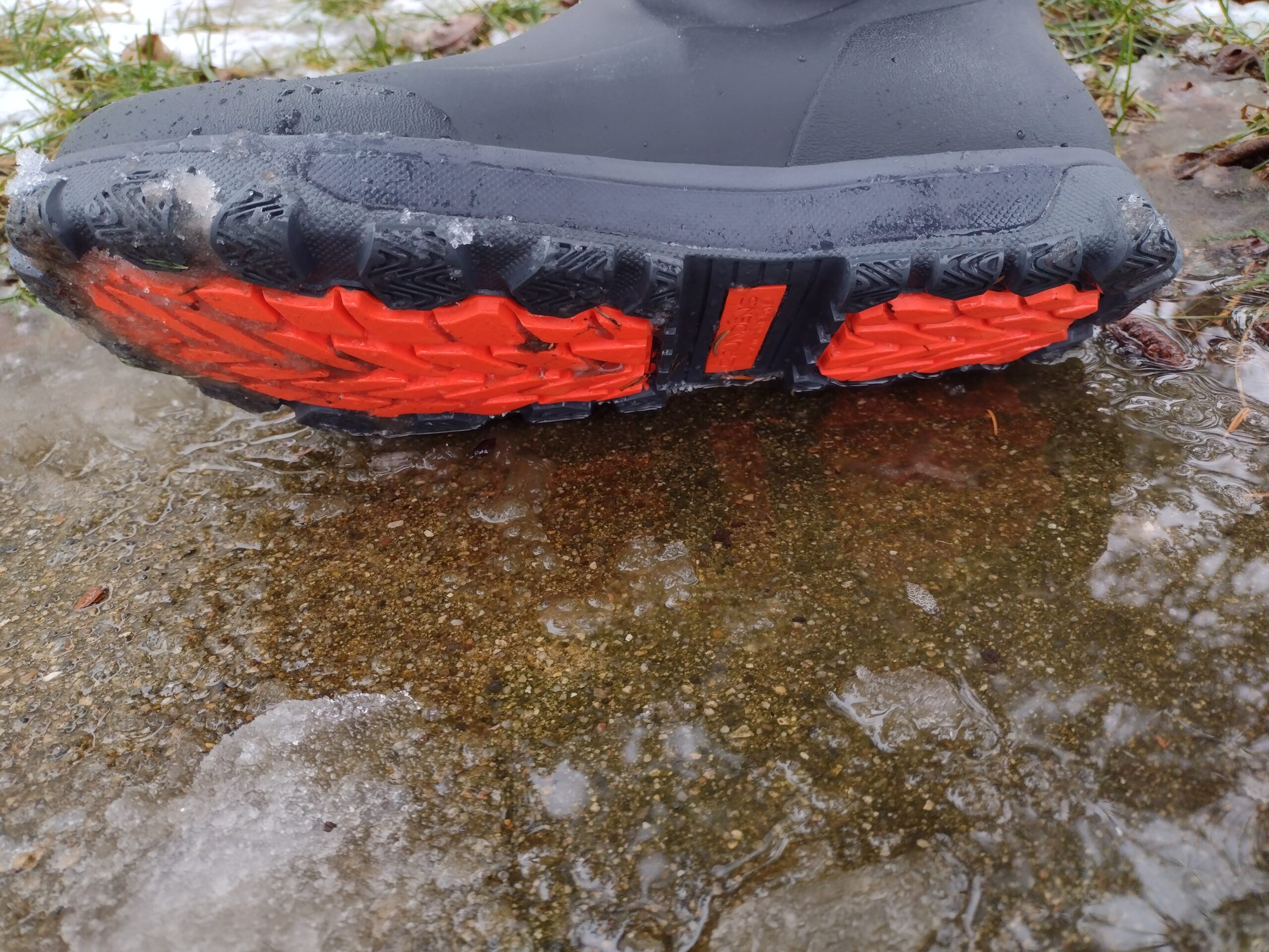 Ground level view of the soles of the black Grundens Deviation Ankle Boot.