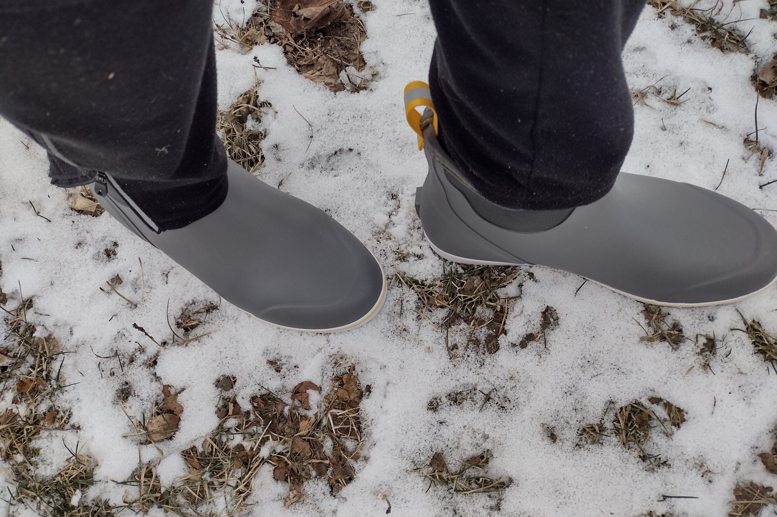 Ground level view of someone wearing the gray XTRATUF Ankle Deck Boot in light snow.